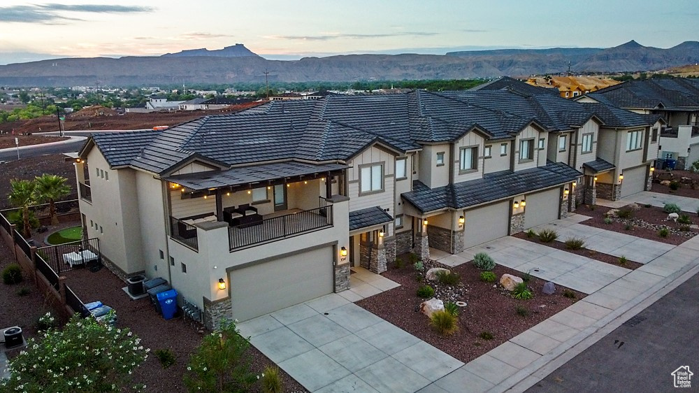 View of front of home with a mountain view, a garage, and cooling unit