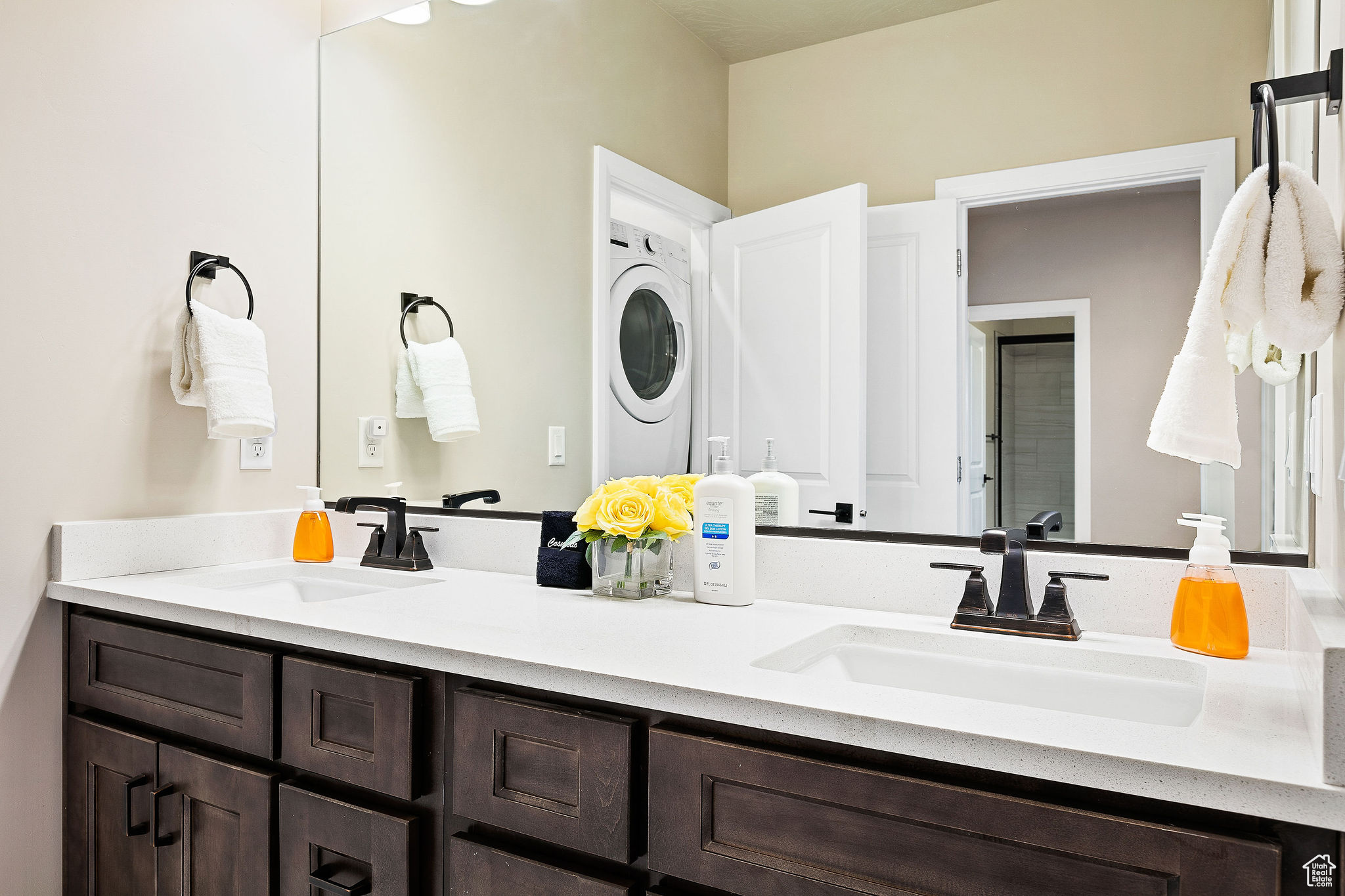 Bathroom featuring stacked washing maching and dryer and vanity