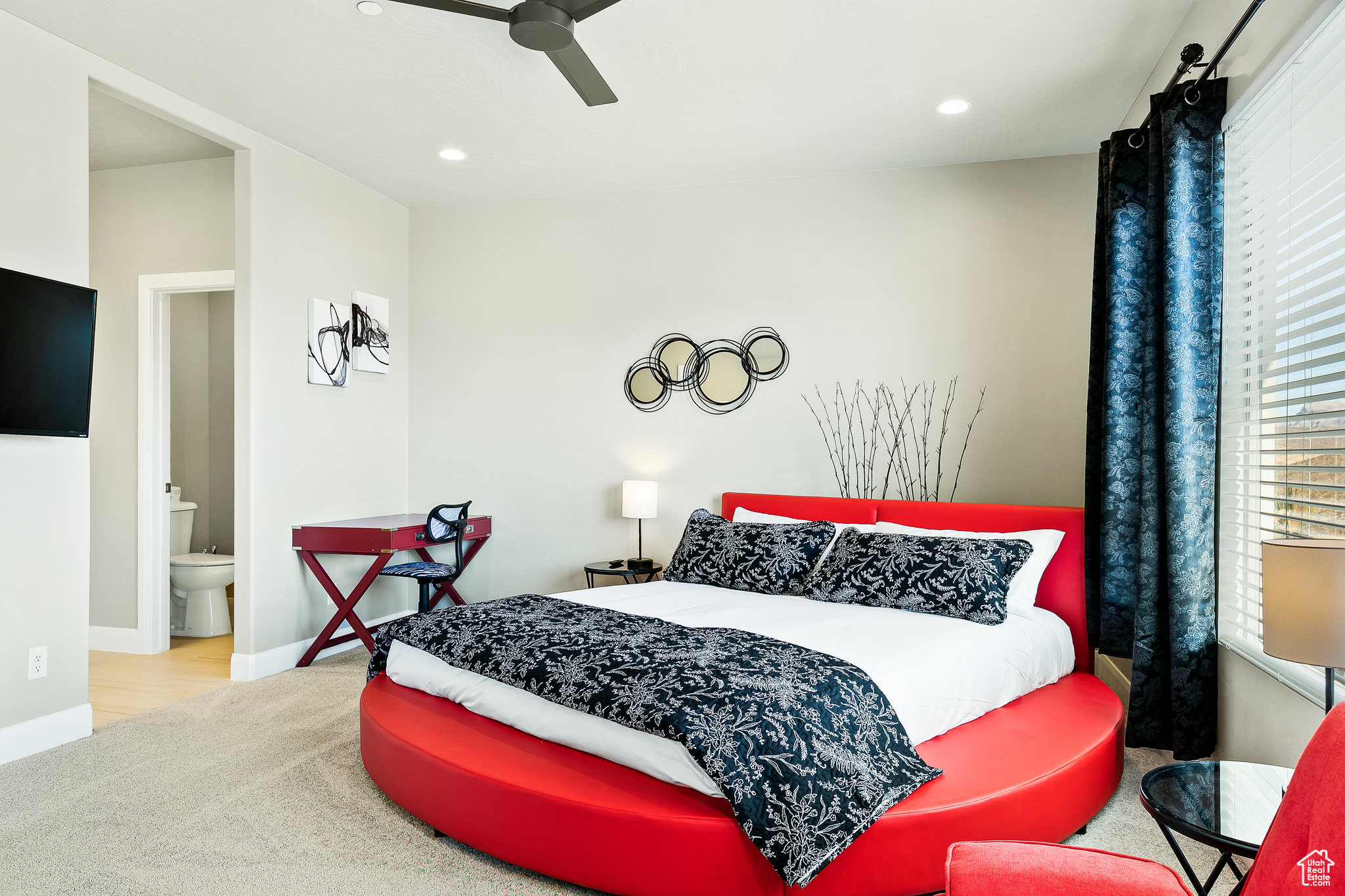 Bedroom with ceiling fan, ensuite bath, and light carpet