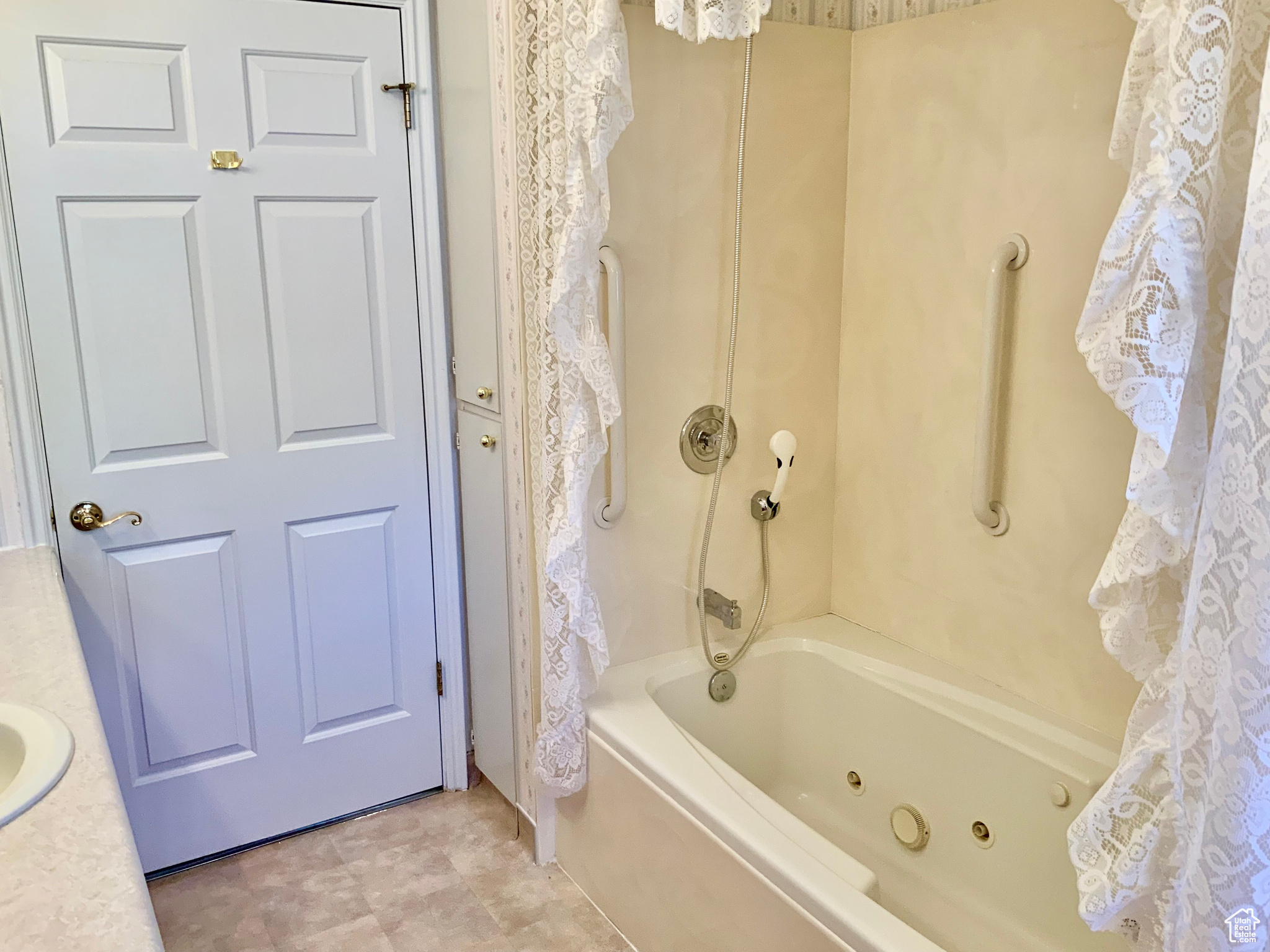 Bathroom featuring shower / bath combination with curtain and sink
