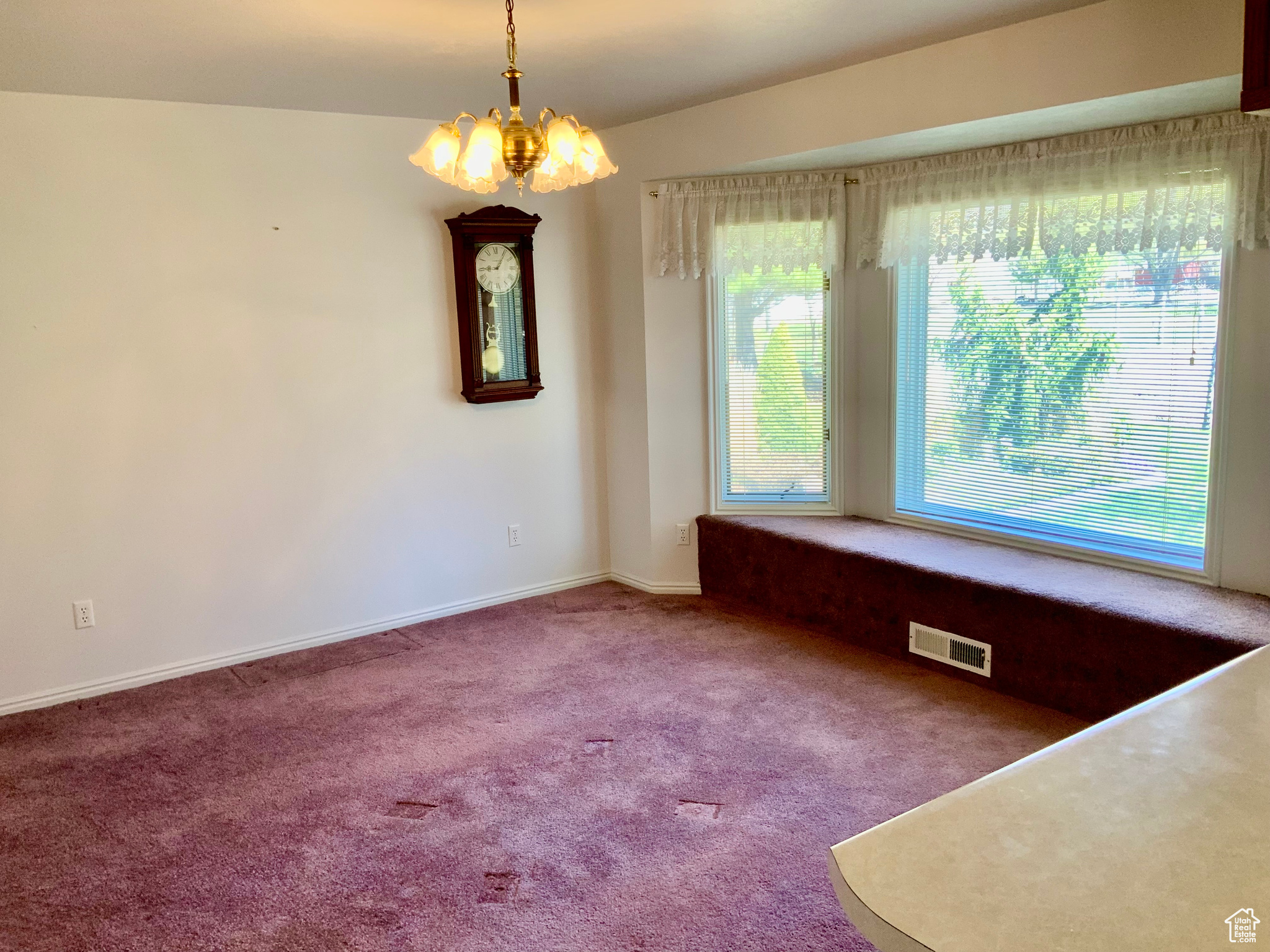 Unfurnished dining area featuring an inviting chandelier and carpet floors