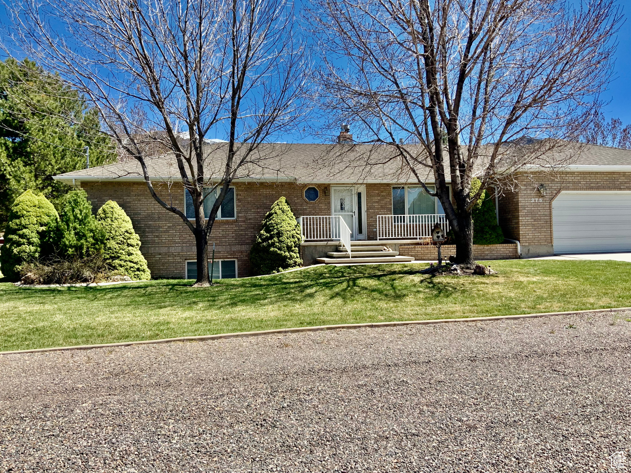 Ranch-style home featuring a garage and a front lawn