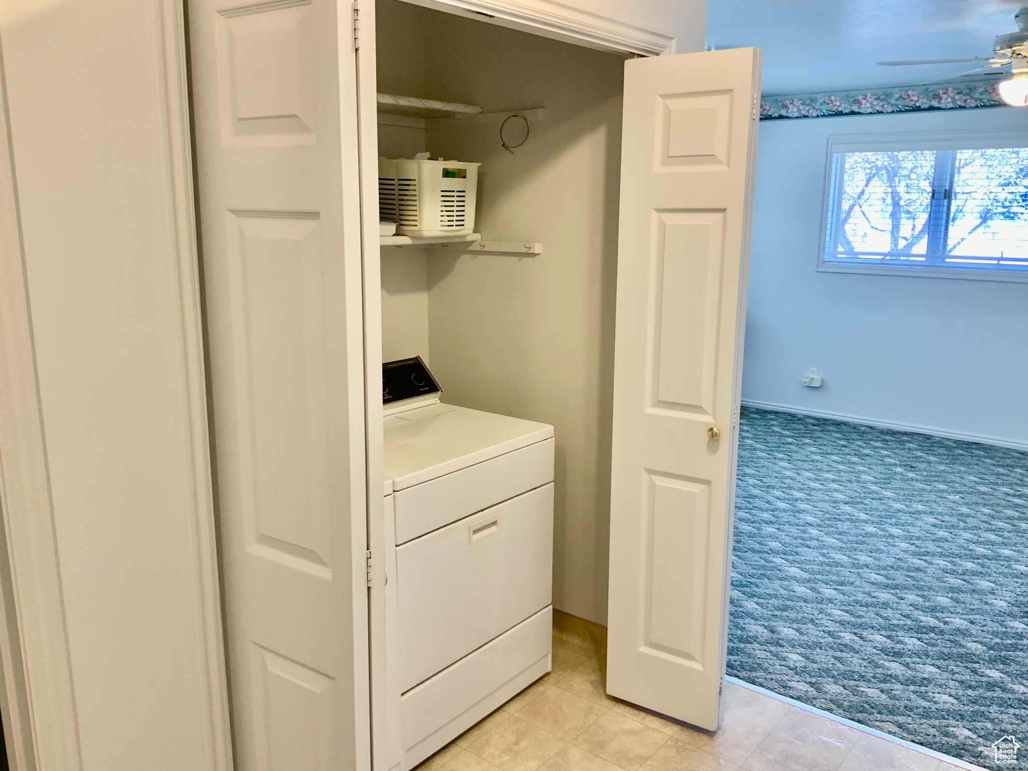 Laundry room featuring washer / clothes dryer, light carpet, and ceiling fan
