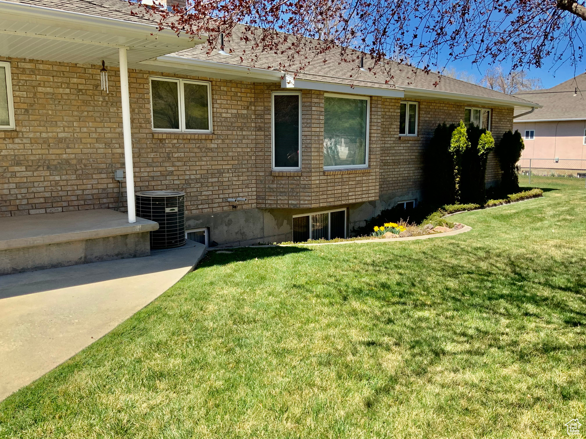View of side of property featuring cooling unit and a lawn