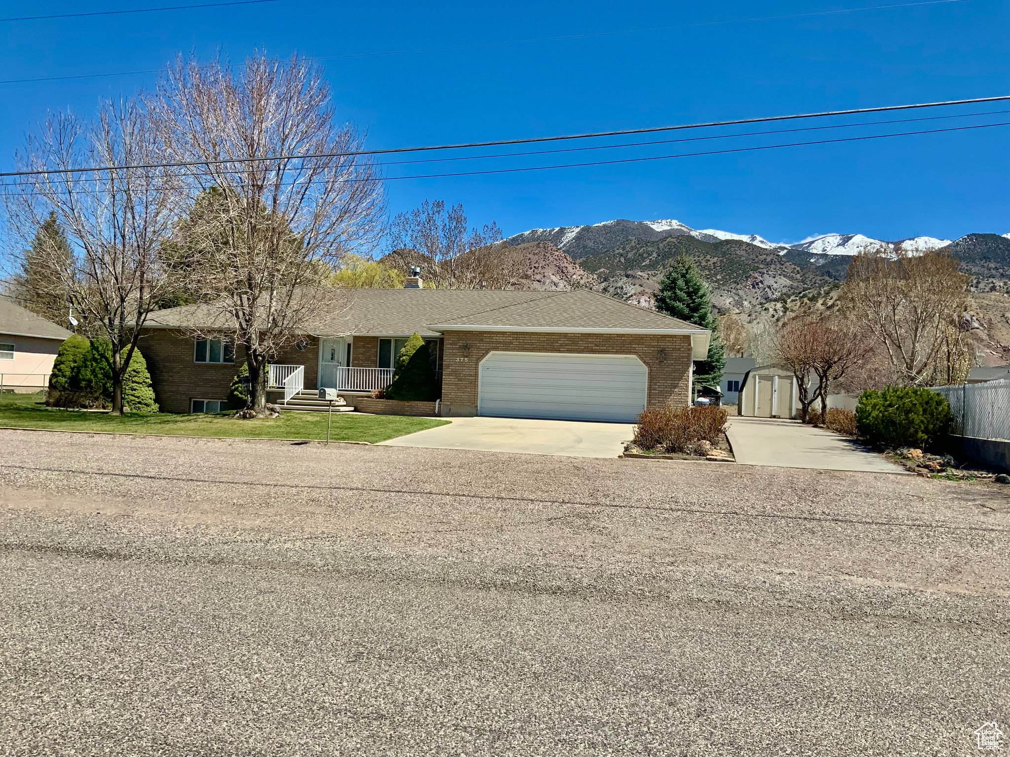Ranch-style home with a garage, a shed, and a mountain view