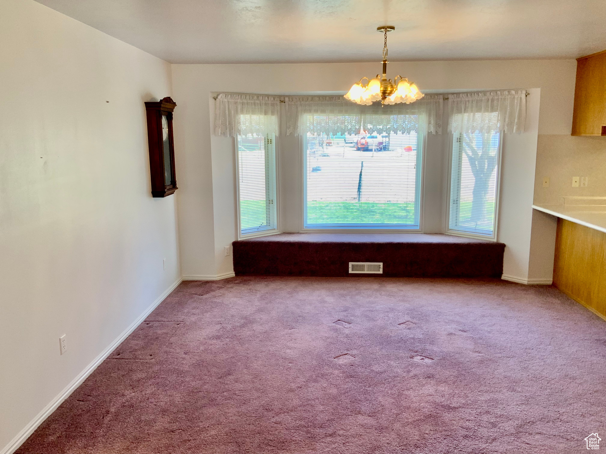 Unfurnished dining area featuring carpet flooring and a chandelier