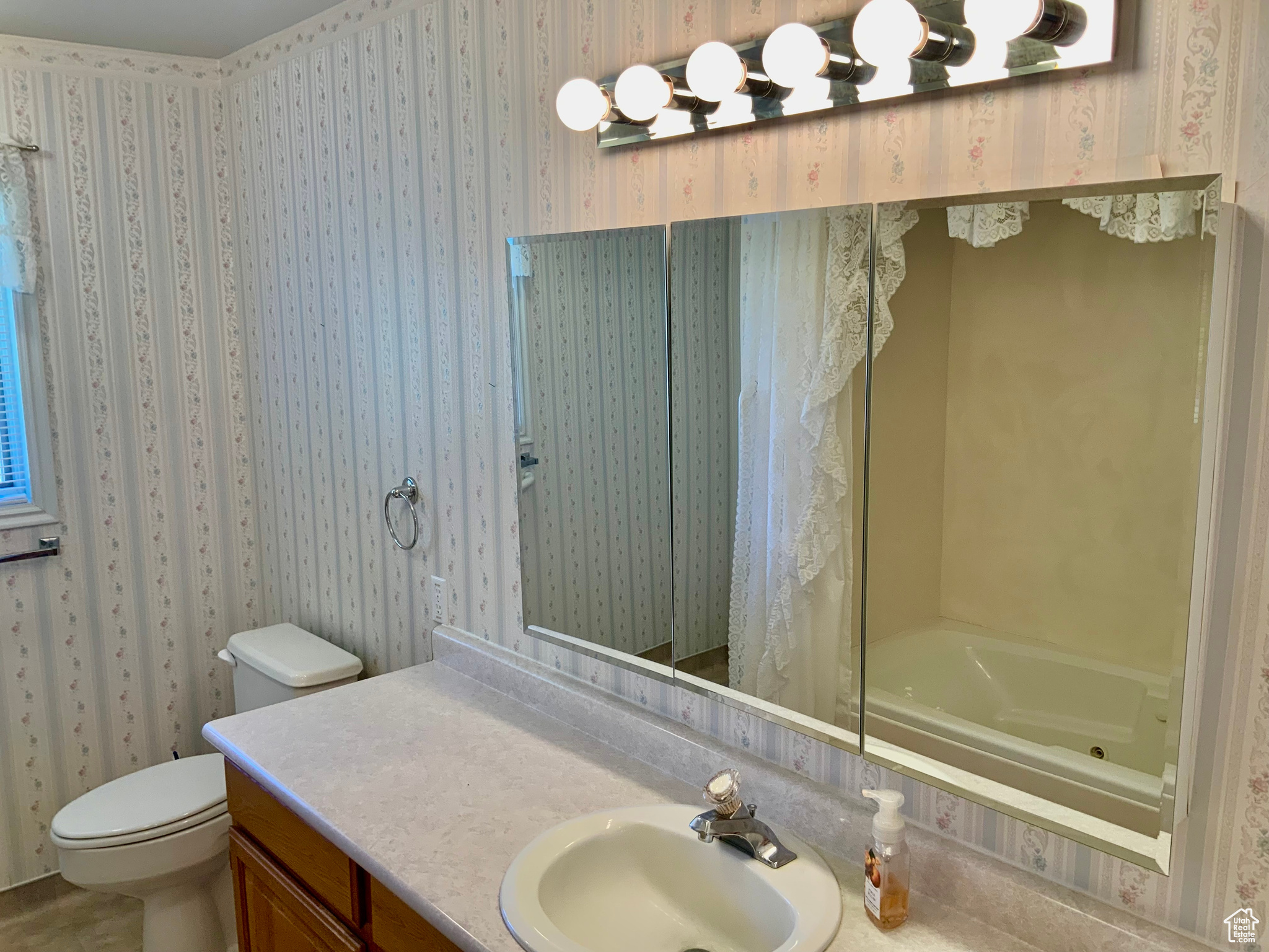 Full bathroom featuring shower / tub combo with curtain, vanity, and toilet