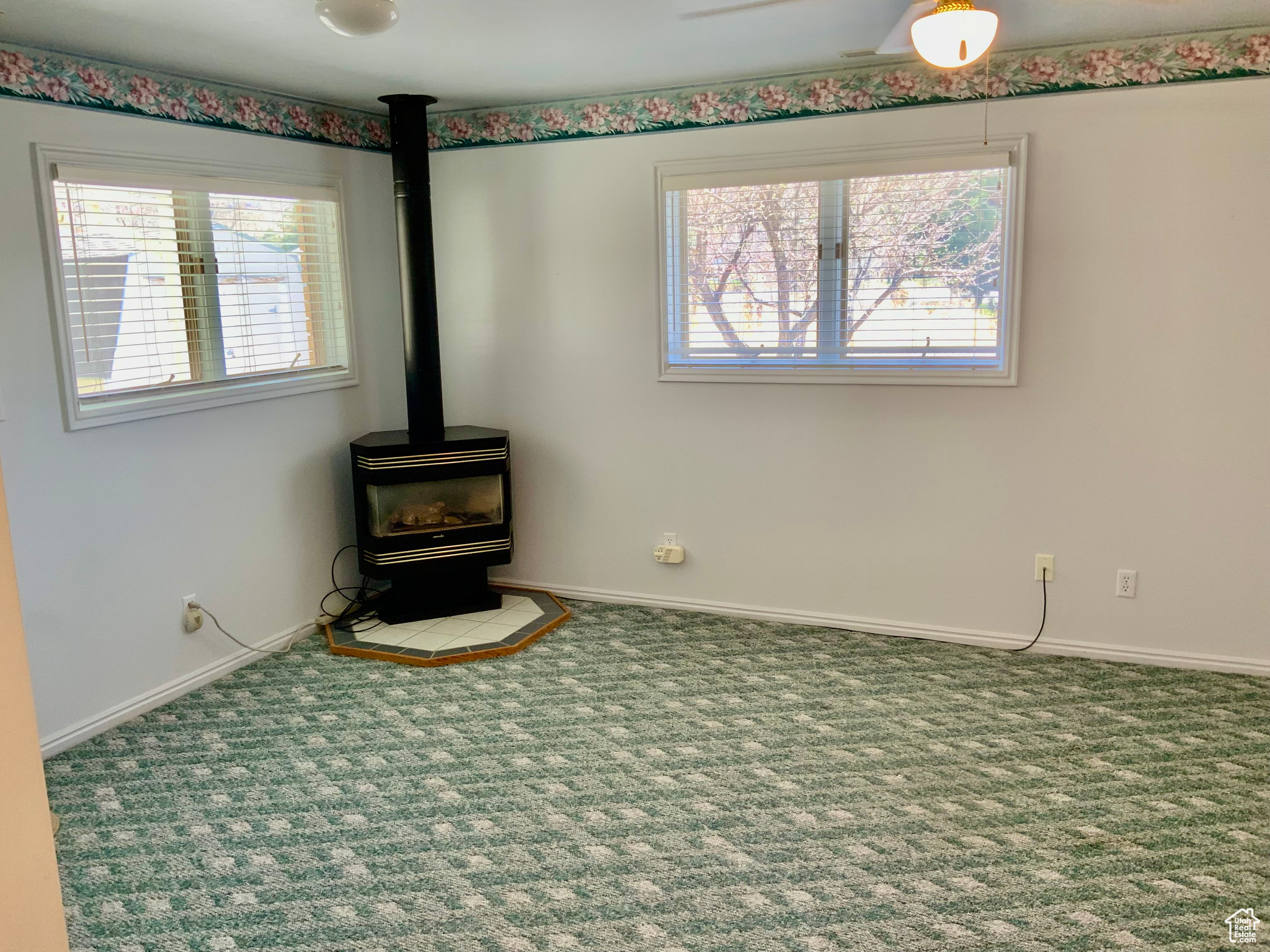 Unfurnished living room with carpet flooring and a wood stove
