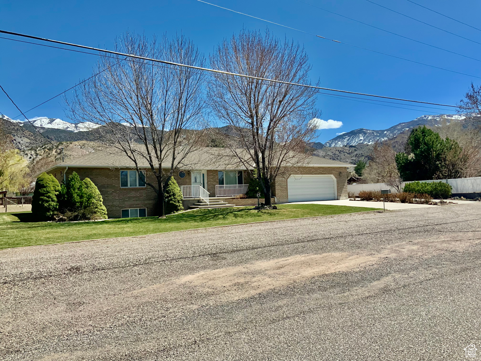 Single story home featuring a garage, a mountain view, and a front yard