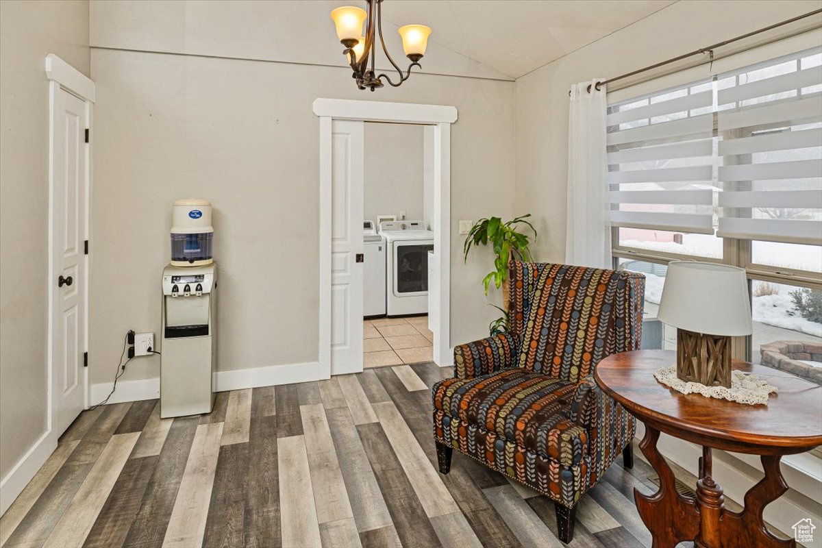 Dining room with lofted ceiling, hardwood / wood-style flooring, a chandelier, and washing machine and clothes dryer