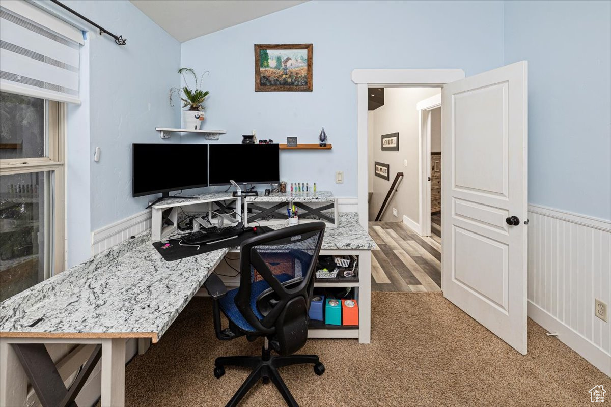 Carpeted office space with vaulted ceiling