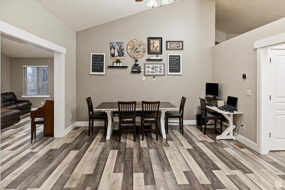 Dining room with hardwood / wood-style floors and lofted ceiling