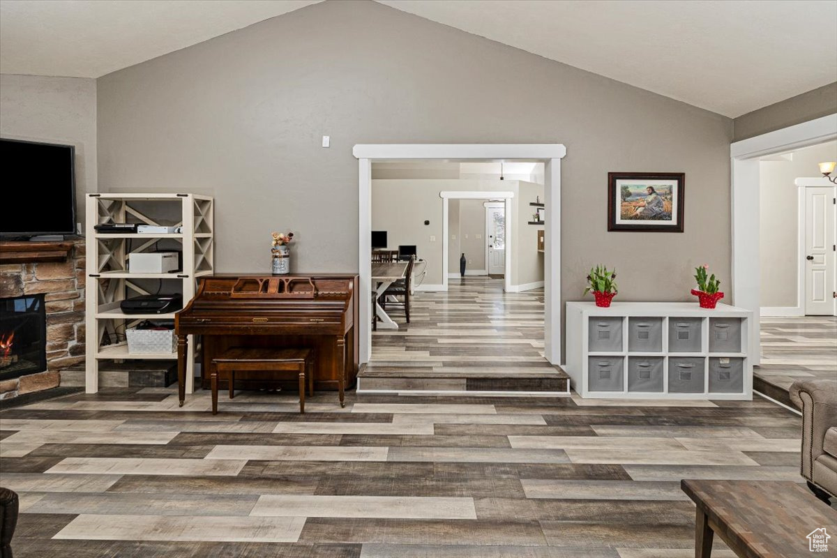 Sitting room featuring a fireplace, vaulted ceiling, and hardwood / wood-style flooring