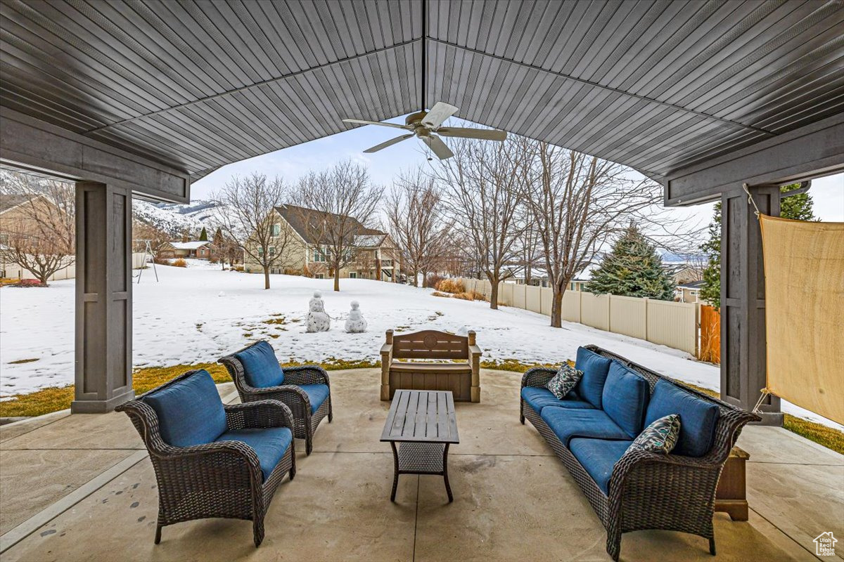 Snow covered patio featuring outdoor lounge area and ceiling fan