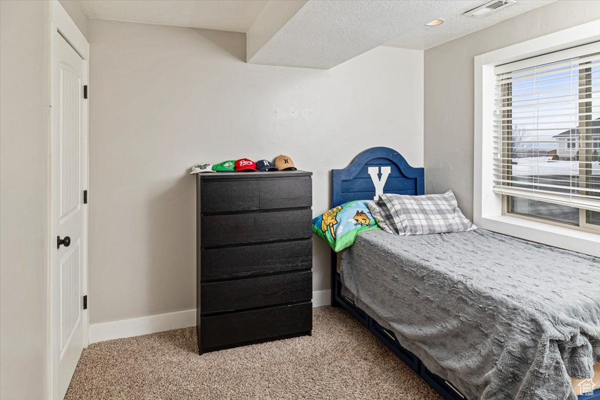 Carpeted bedroom with a textured ceiling