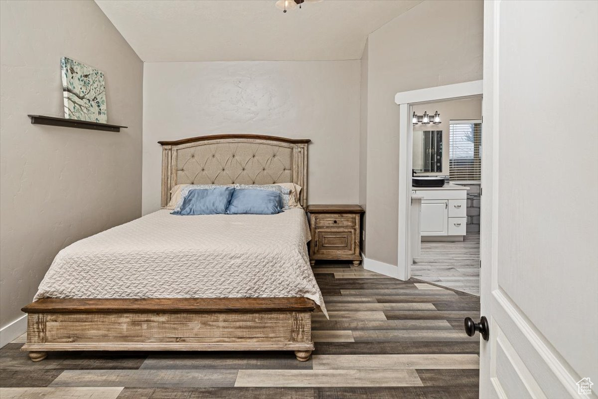 Bedroom featuring ensuite bathroom and dark hardwood / wood-style floors