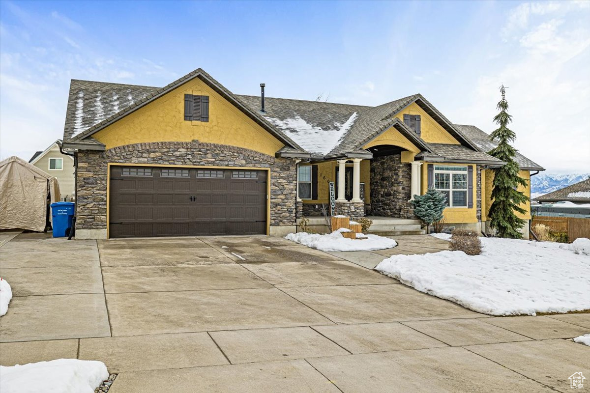 View of front of home featuring stone siding and concrete driveway