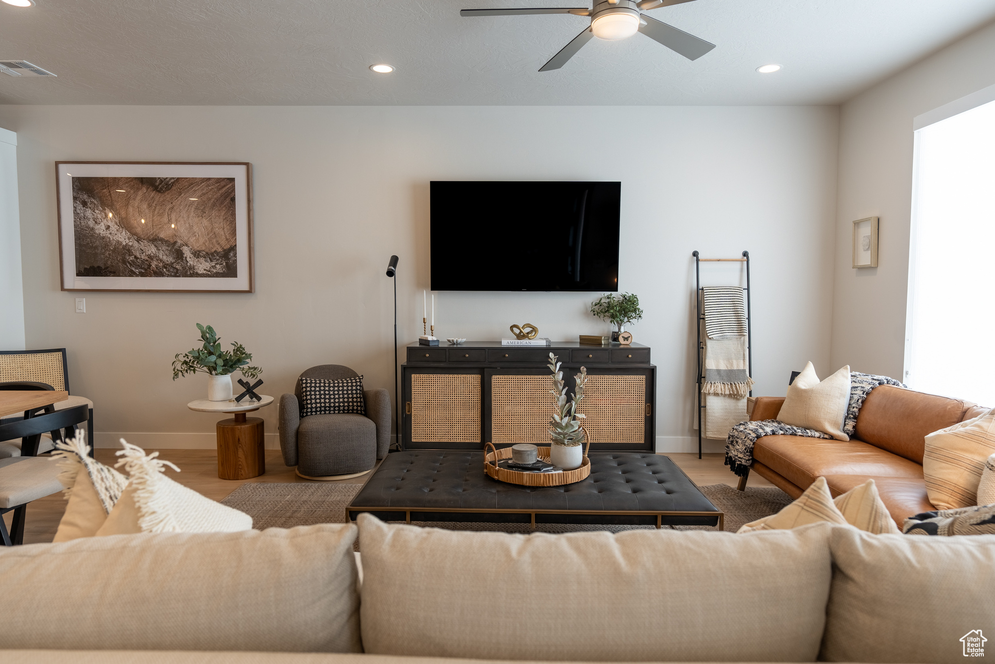 Living room with ceiling fan, a healthy amount of sunlight, and light hardwood / wood-style floors