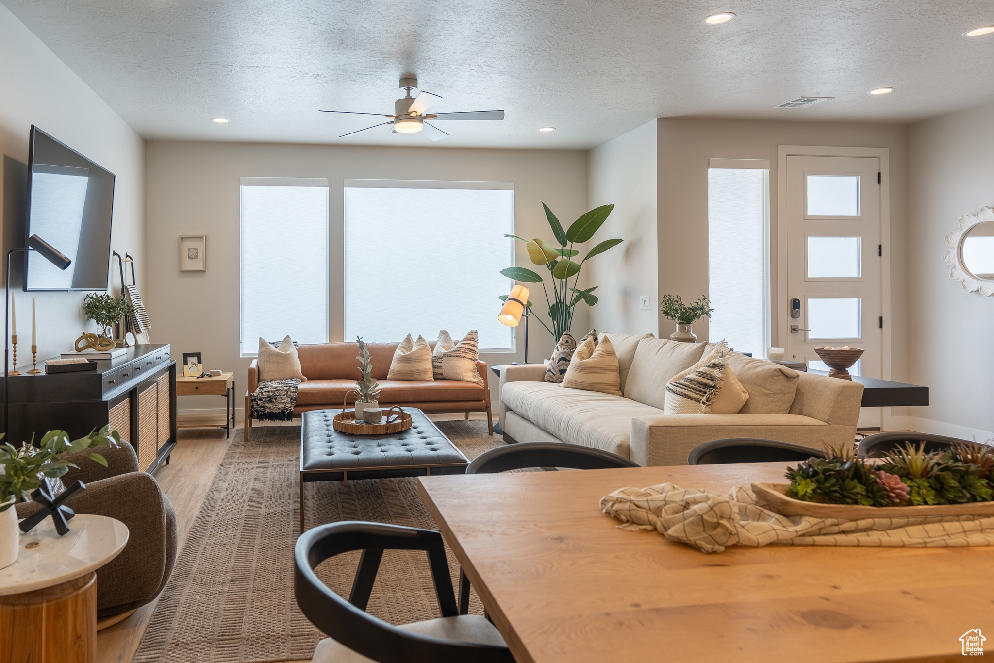 Living room featuring a textured ceiling, hardwood / wood-style flooring, and ceiling fan