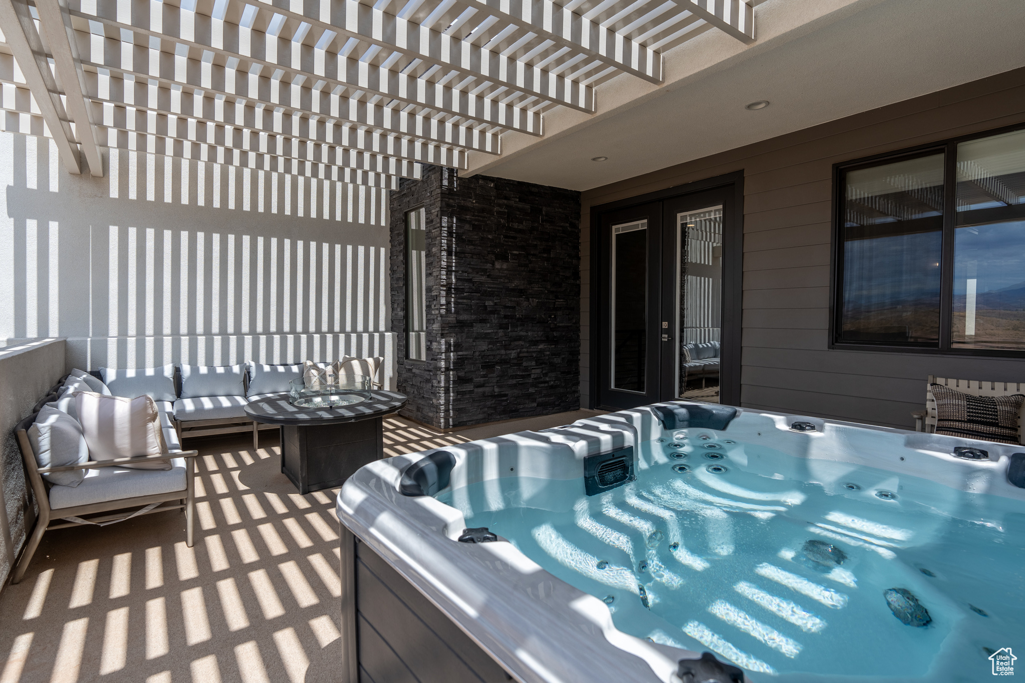 View of patio with a hot tub, an outdoor living space, and a pergola