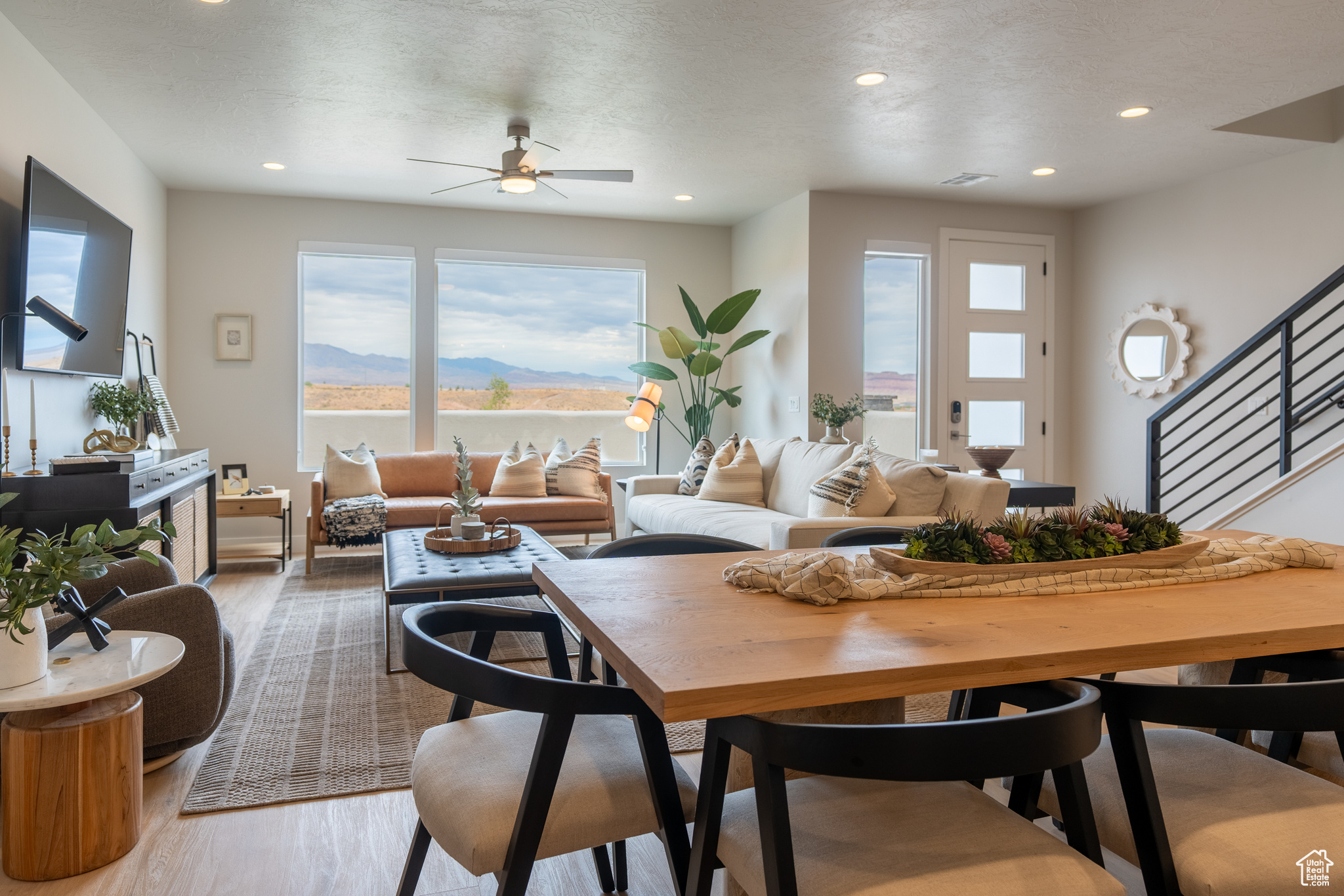 Living room featuring hardwood / wood-style flooring, a mountain view, a textured ceiling, and ceiling fan