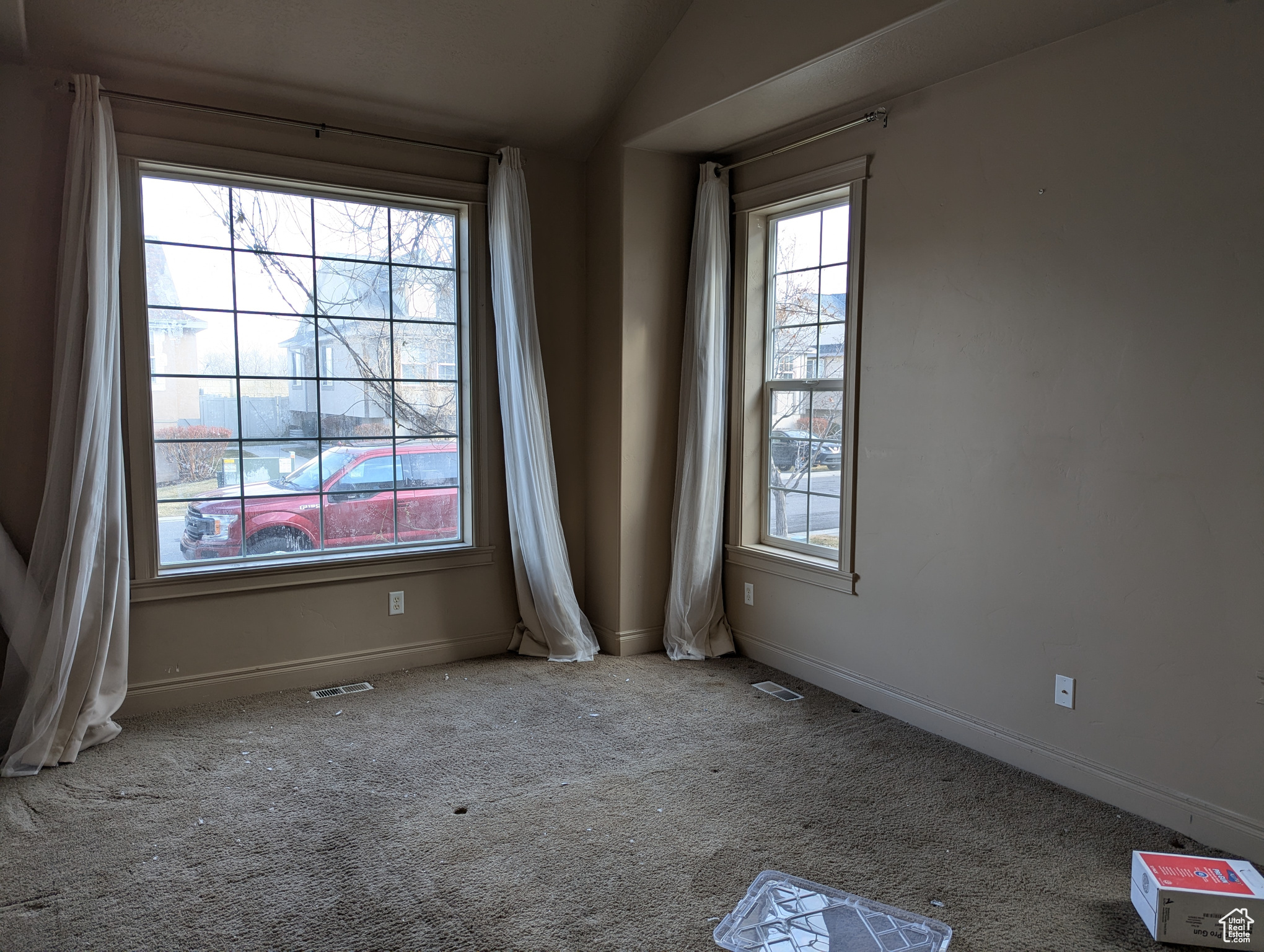 Carpeted spare room with lofted ceiling