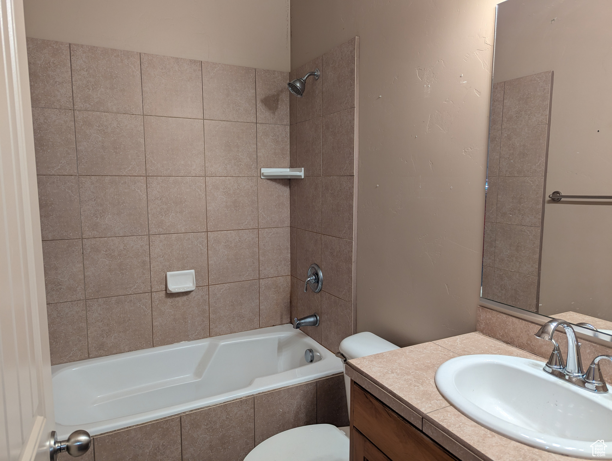 Full bathroom featuring toilet, vanity, and tiled shower / bath combo