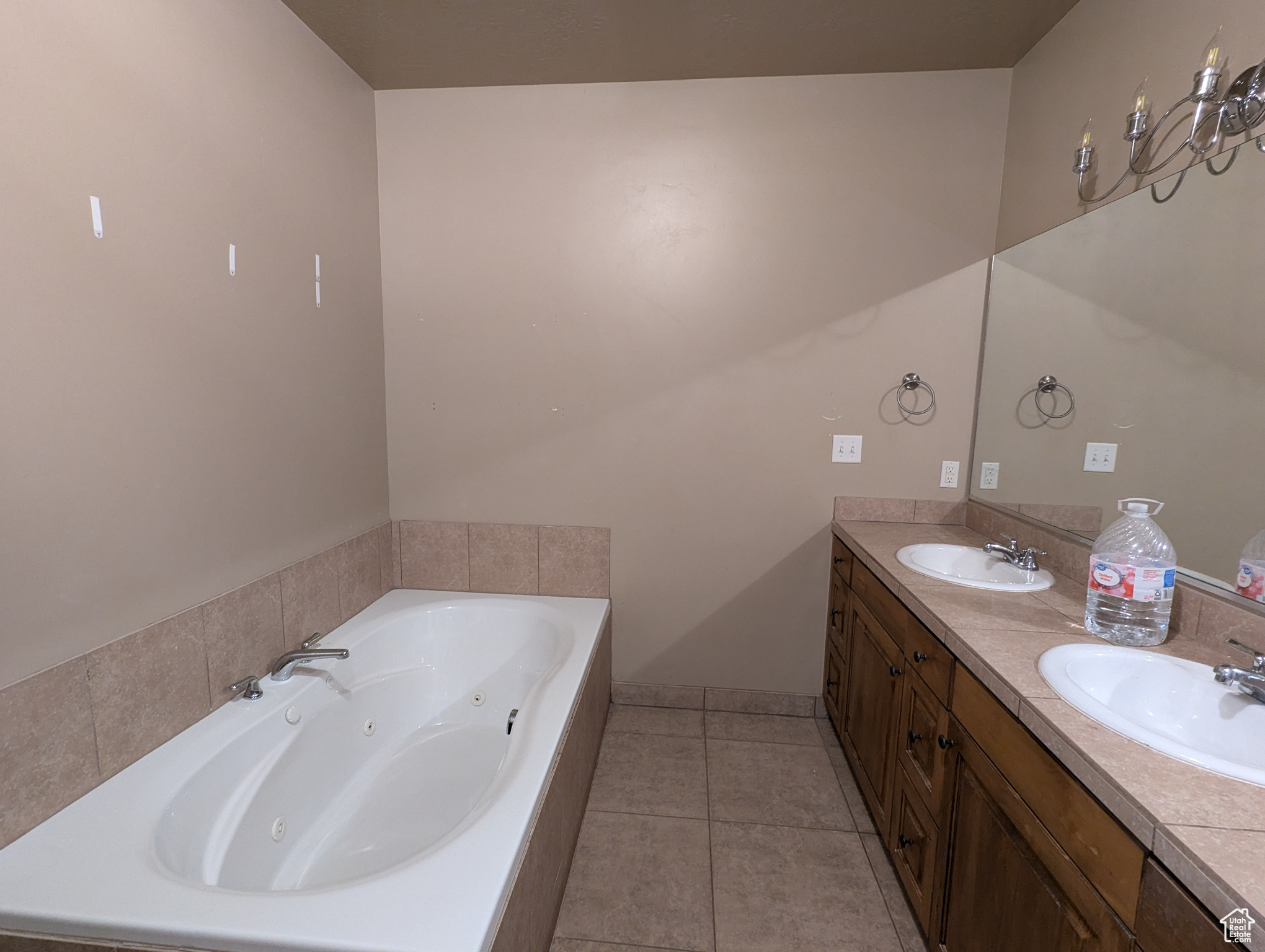 Bathroom with tile patterned flooring, vanity, and tiled tub