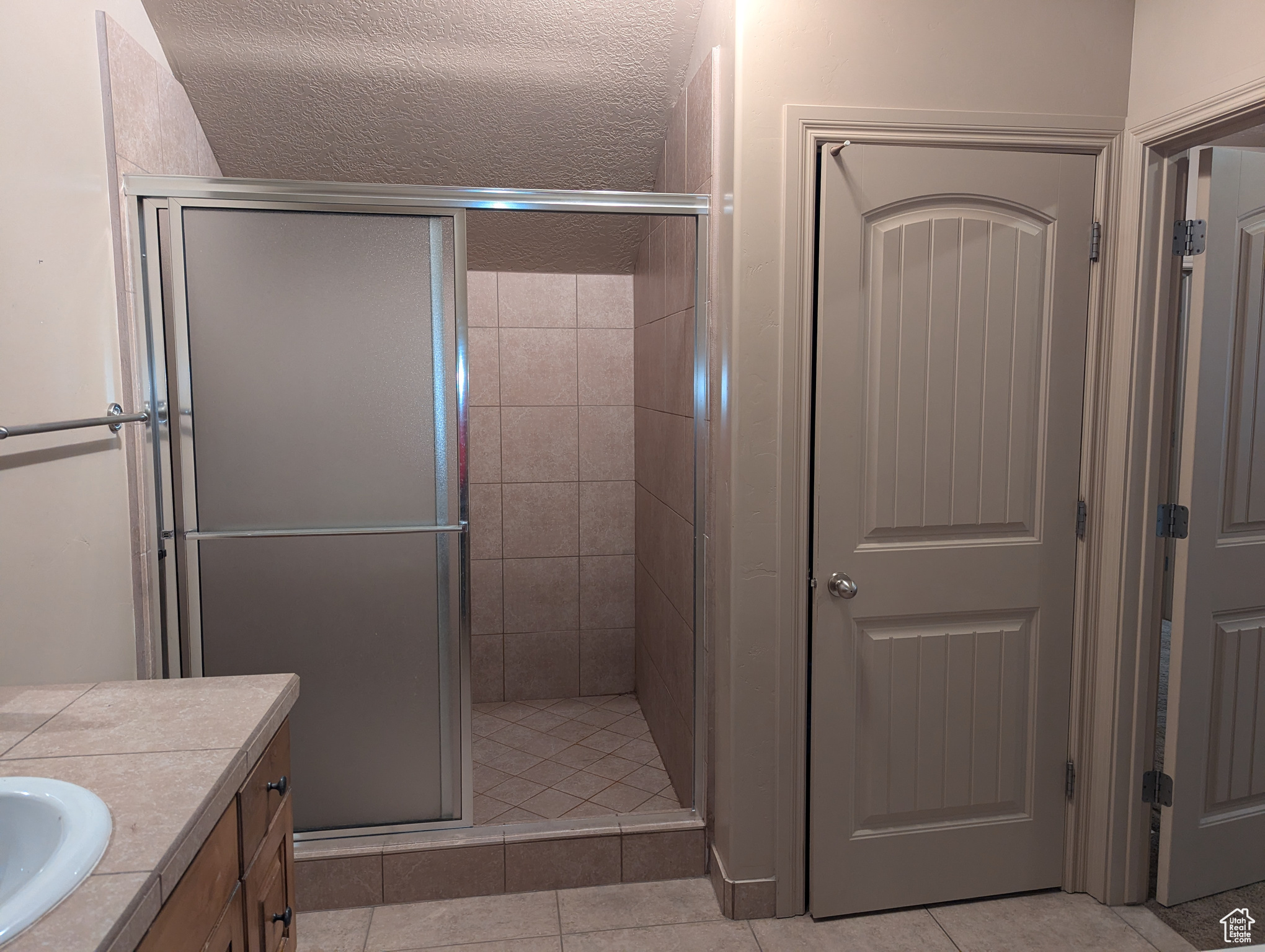 Bathroom featuring vanity, a shower with door, and tile patterned floors