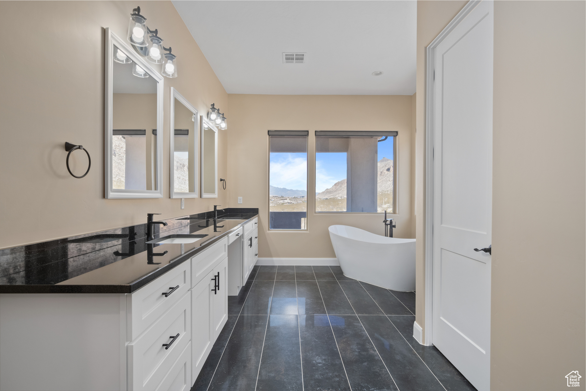 Bathroom featuring vanity, tile patterned flooring, and a tub