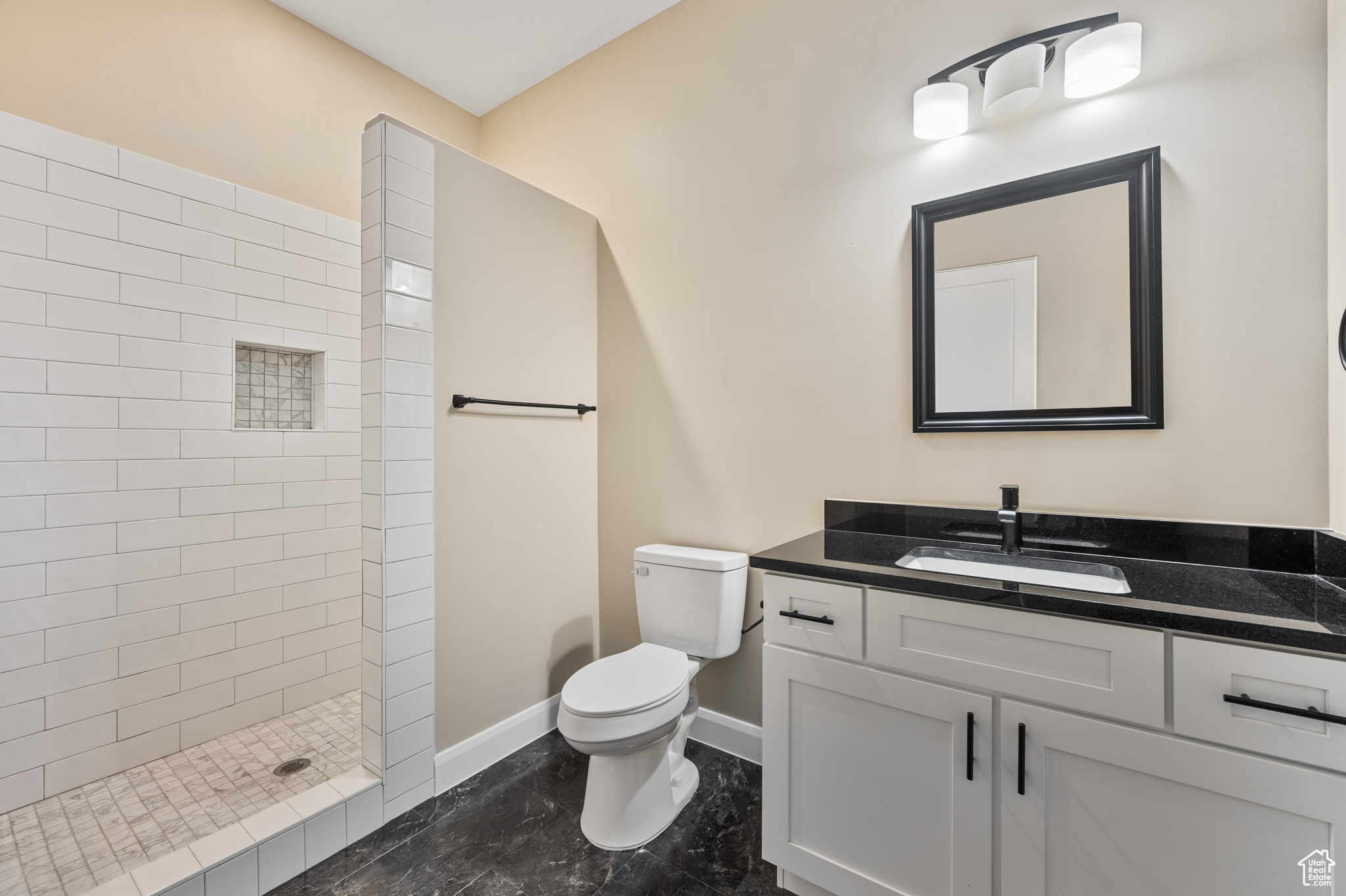 Bathroom with vanity, toilet, and a tile shower