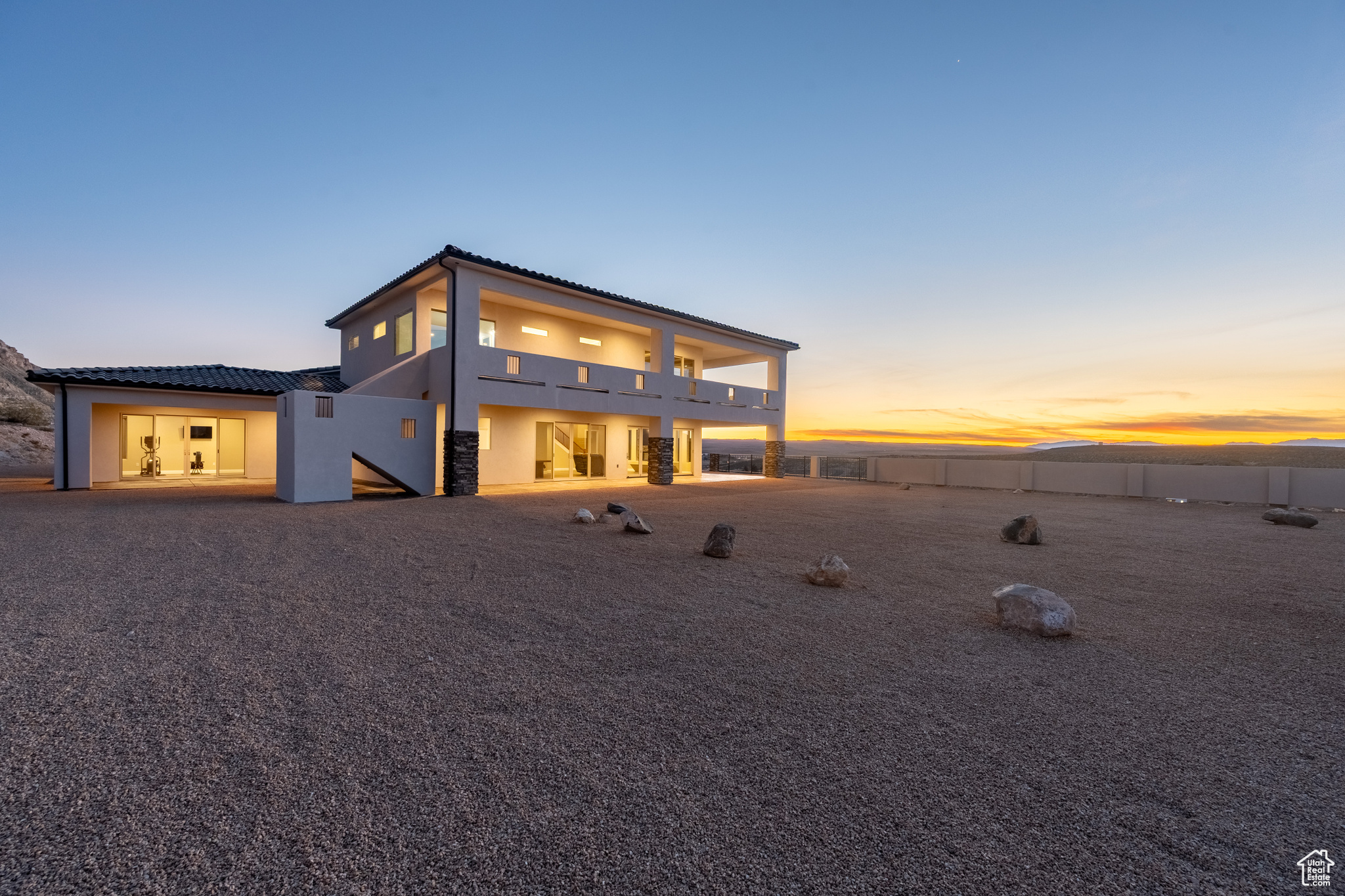 Back of house featuring a patio area, fence, a balcony, and stucco siding