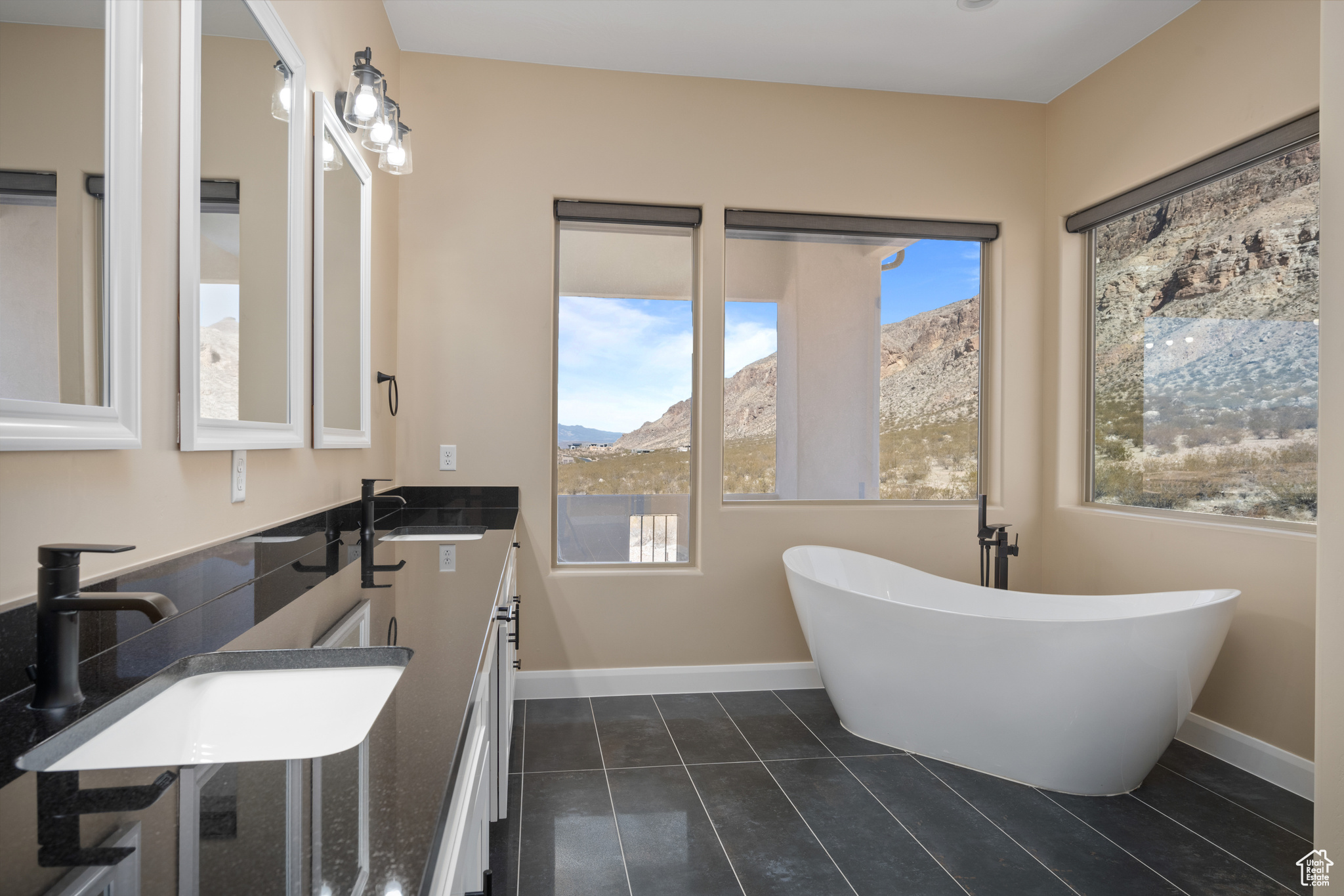 Bathroom with a tub, a mountain view, sink, and tile patterned floors