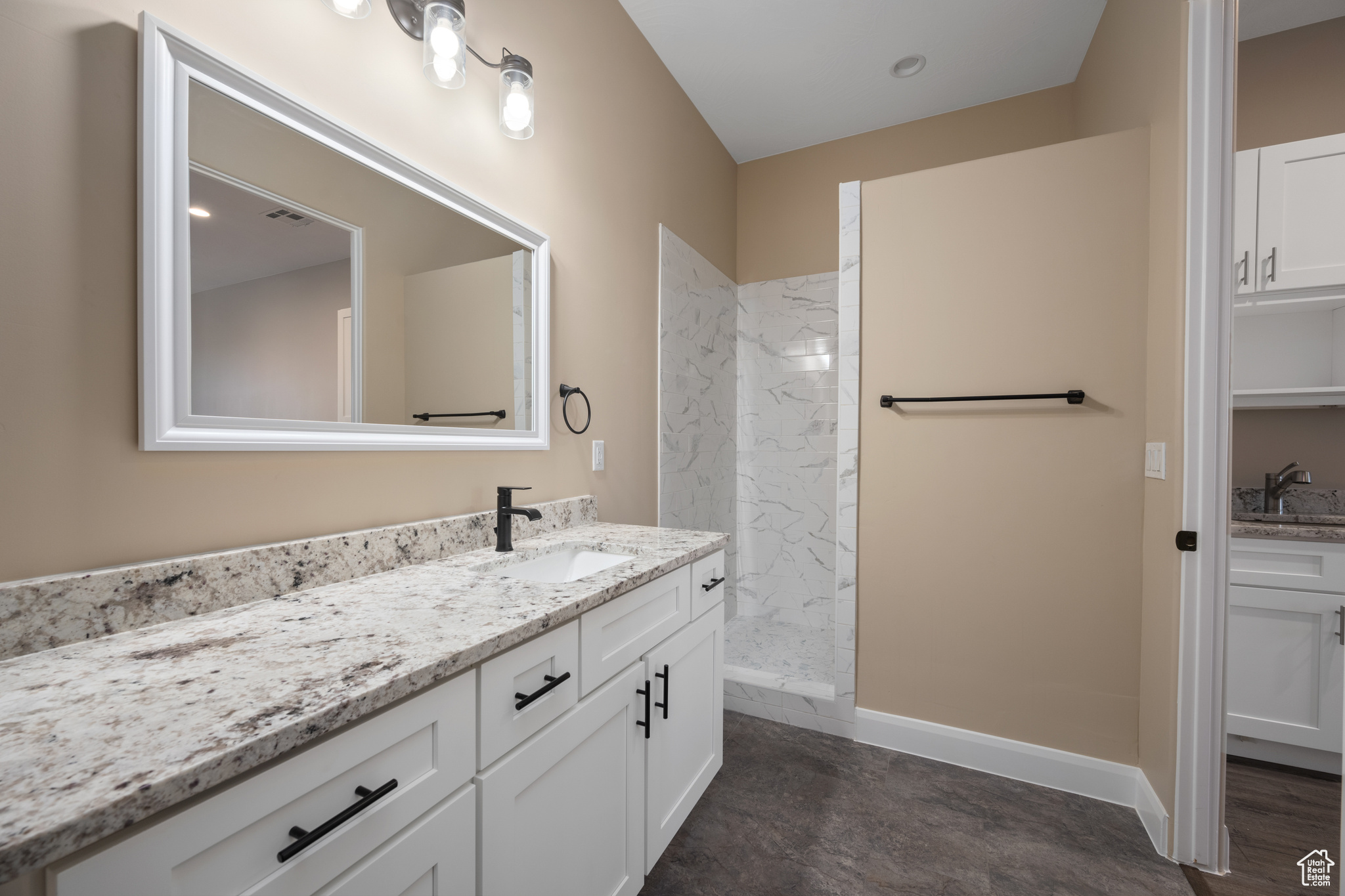 Bathroom featuring vanity and a tile shower