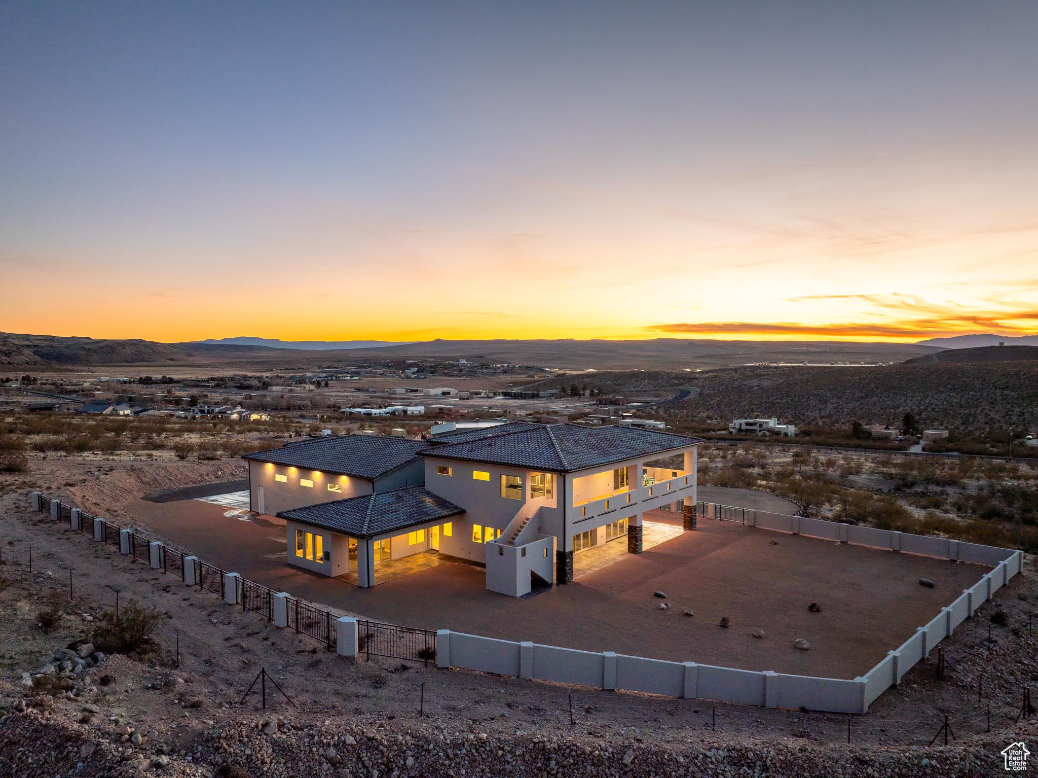 Back of house at dusk featuring a fenced backyard and a mountain view