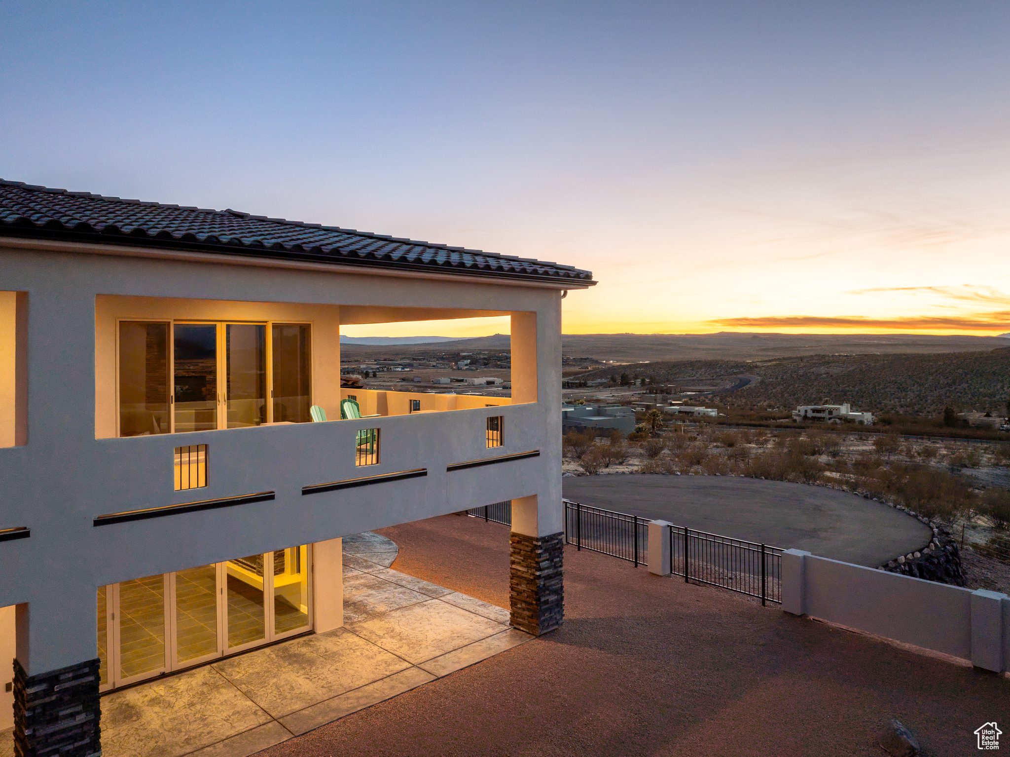 Exterior space featuring a tile roof, fence, and stucco siding