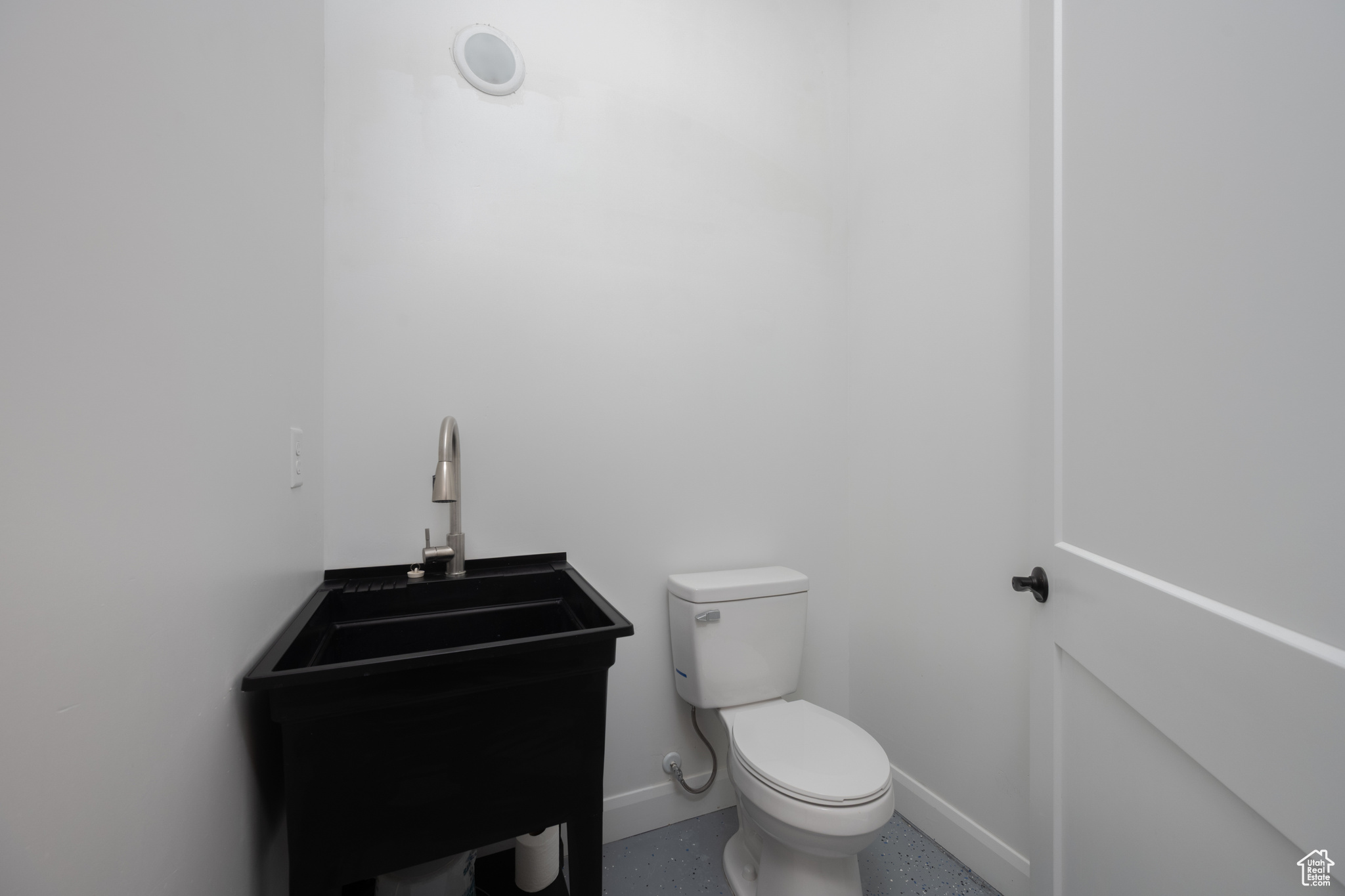 Bathroom featuring baseboards, a sink, and toilet