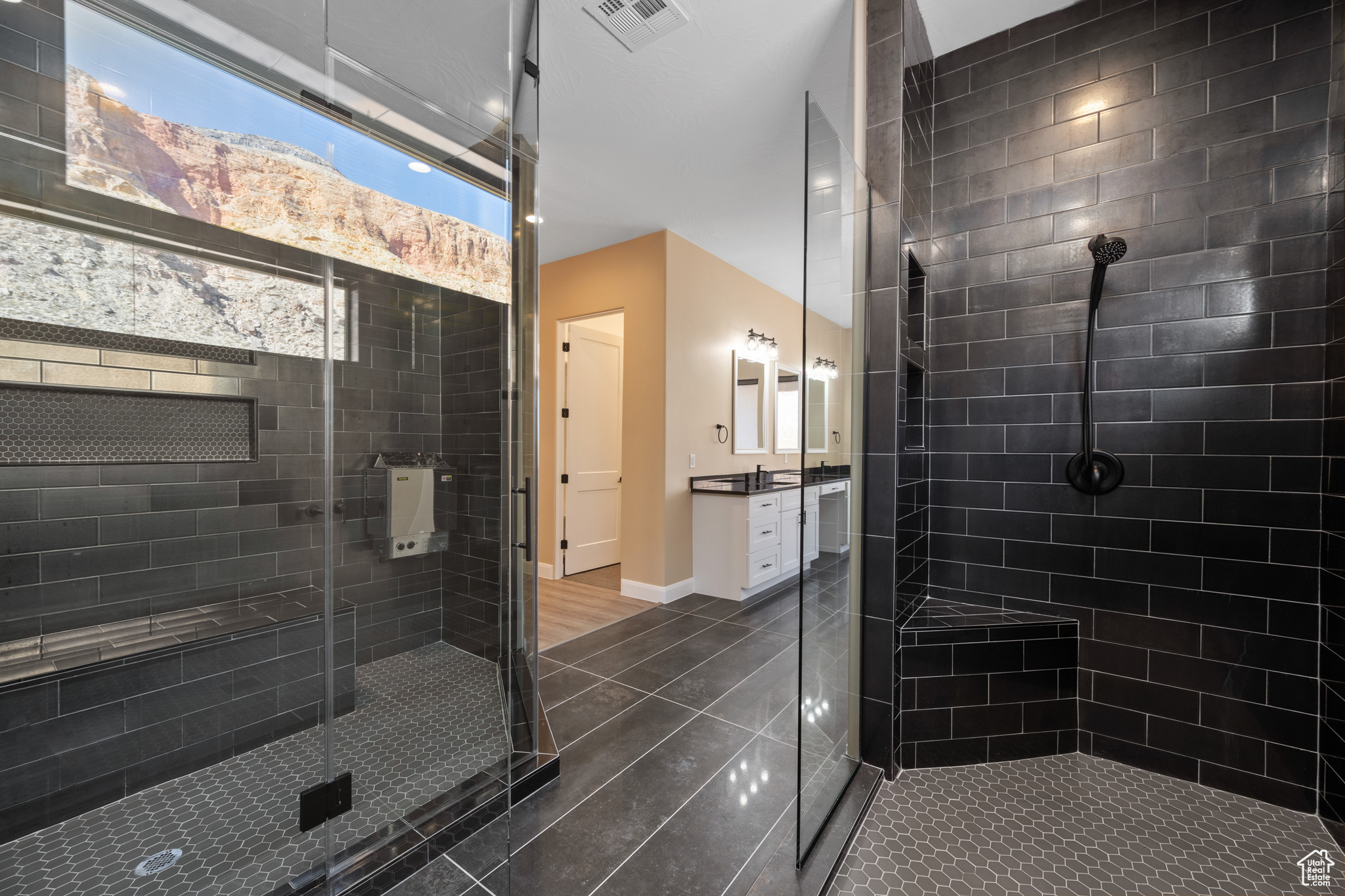 Bathroom with tile patterned flooring, vanity, and tiled shower