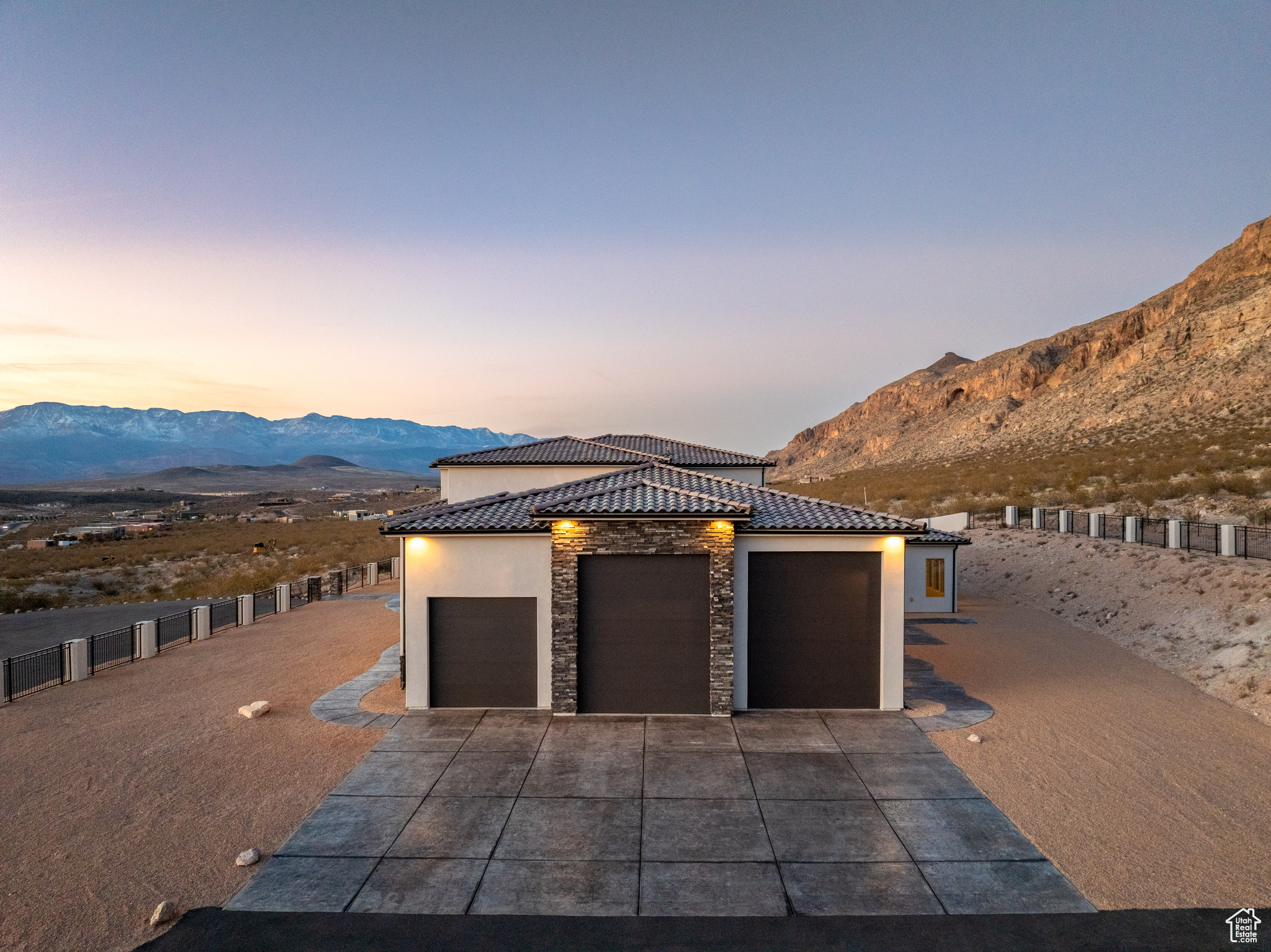 View of front of property with stone siding, a mountain view, and stucco siding