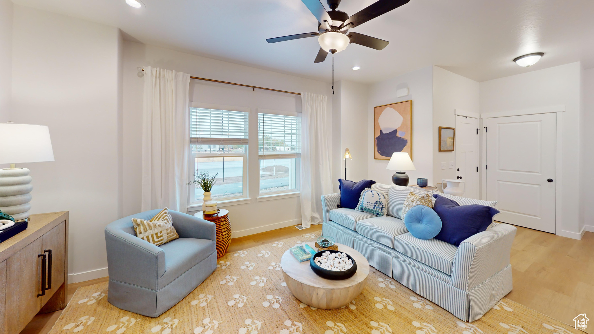 Living room with ceiling fan and light hardwood / wood-style floors