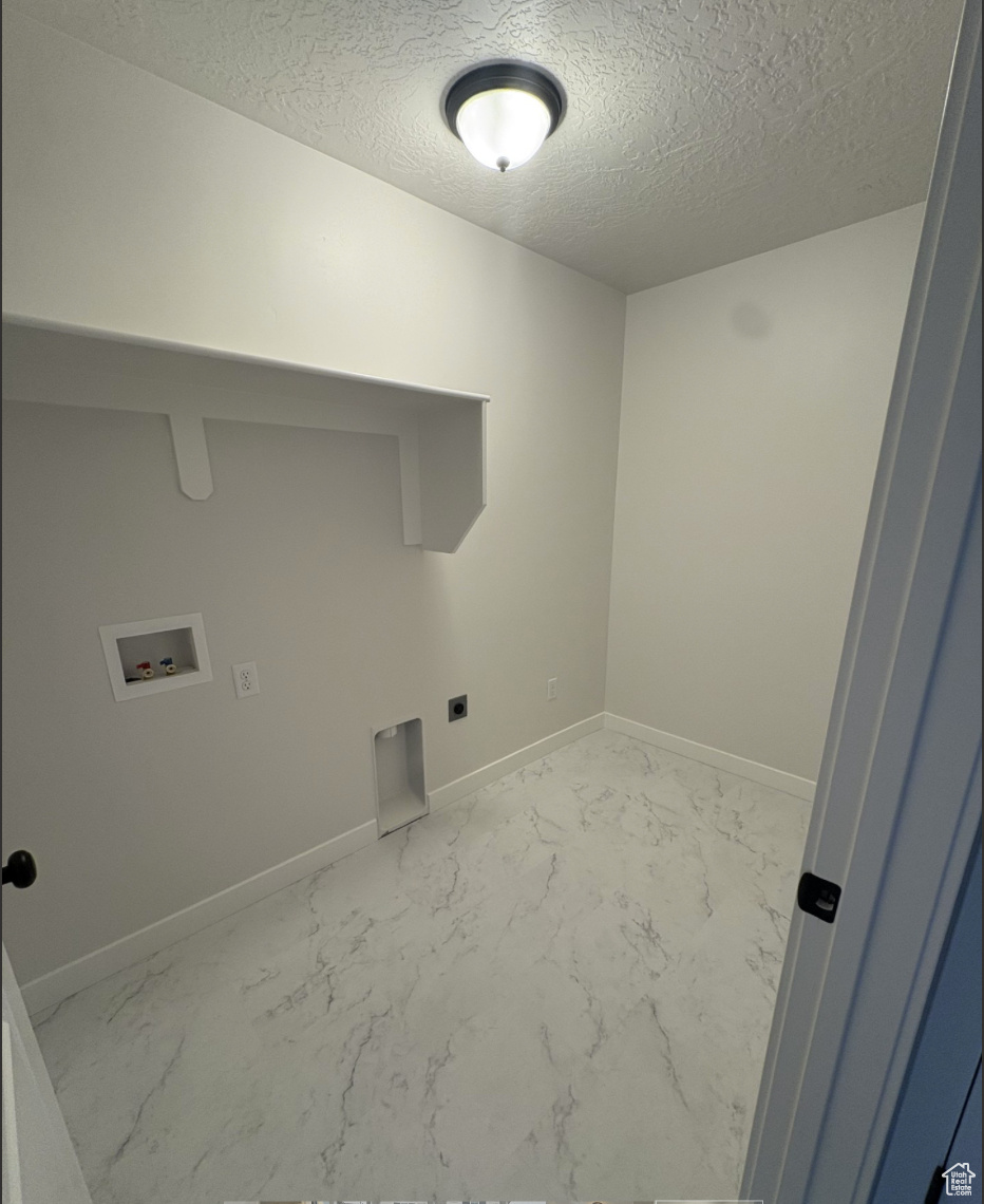 Laundry area featuring washer hookup, a textured ceiling, and electric dryer hookup