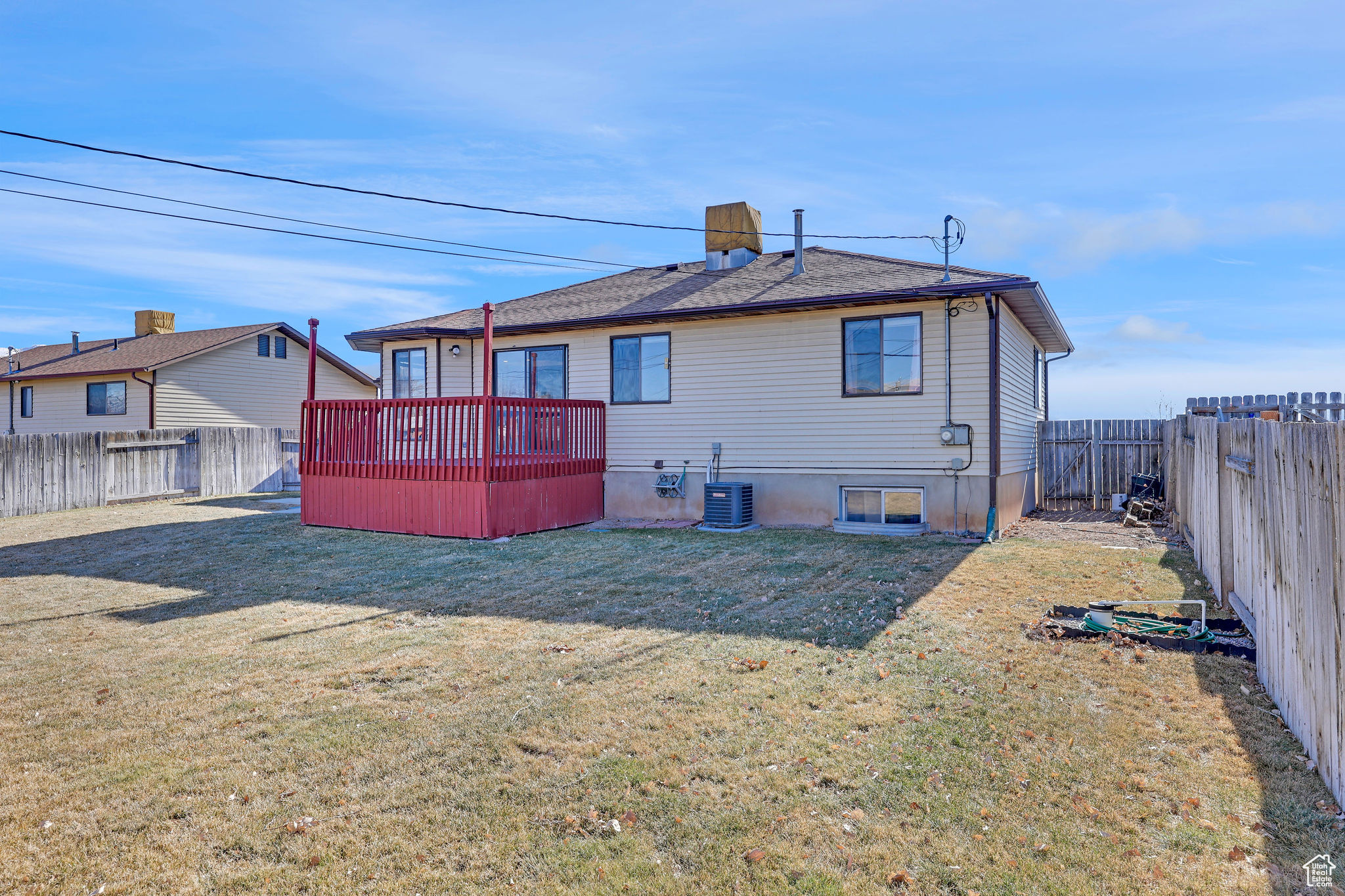 Back of house with a yard, central air condition unit, and a wooden deck