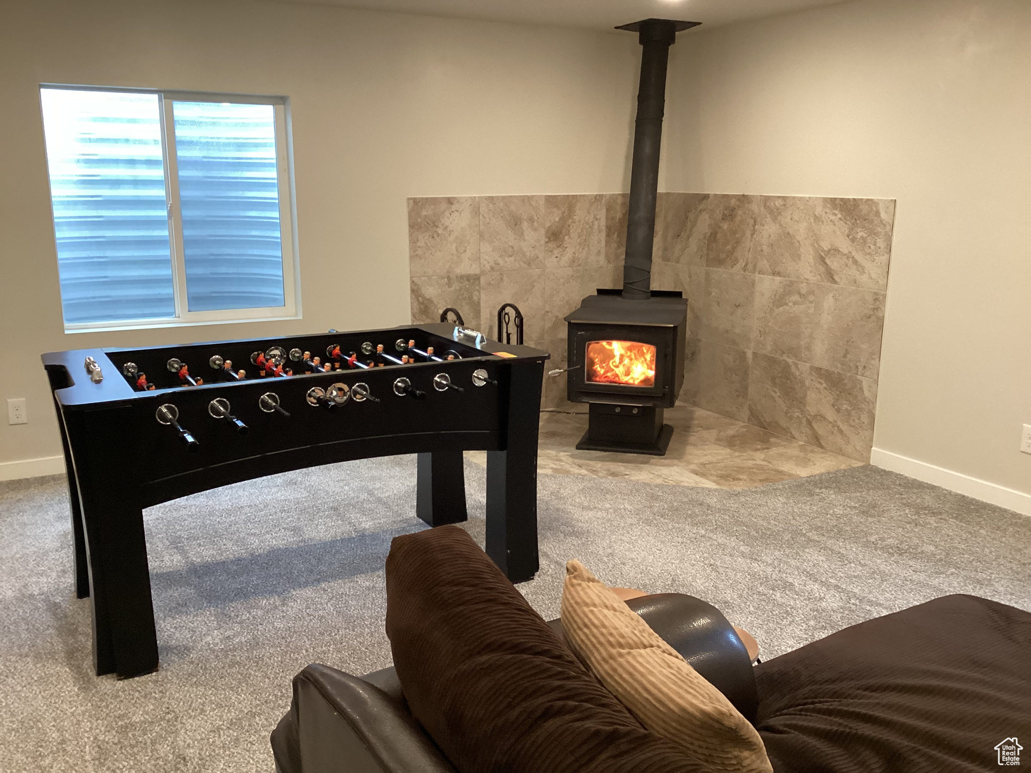 Rec room featuring carpet flooring and a wood stove