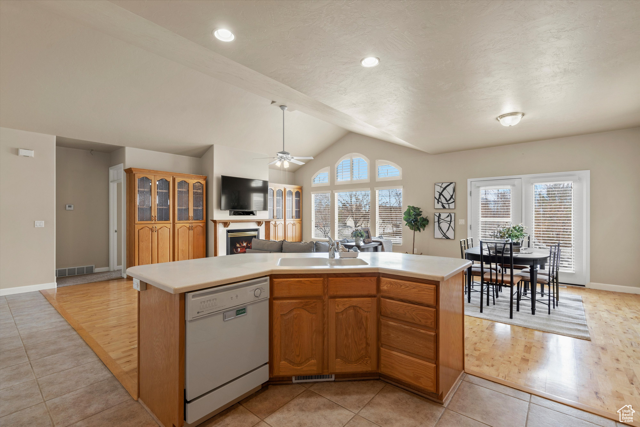 Kitchen featuring sink, dishwasher, a center island, and lofted ceiling