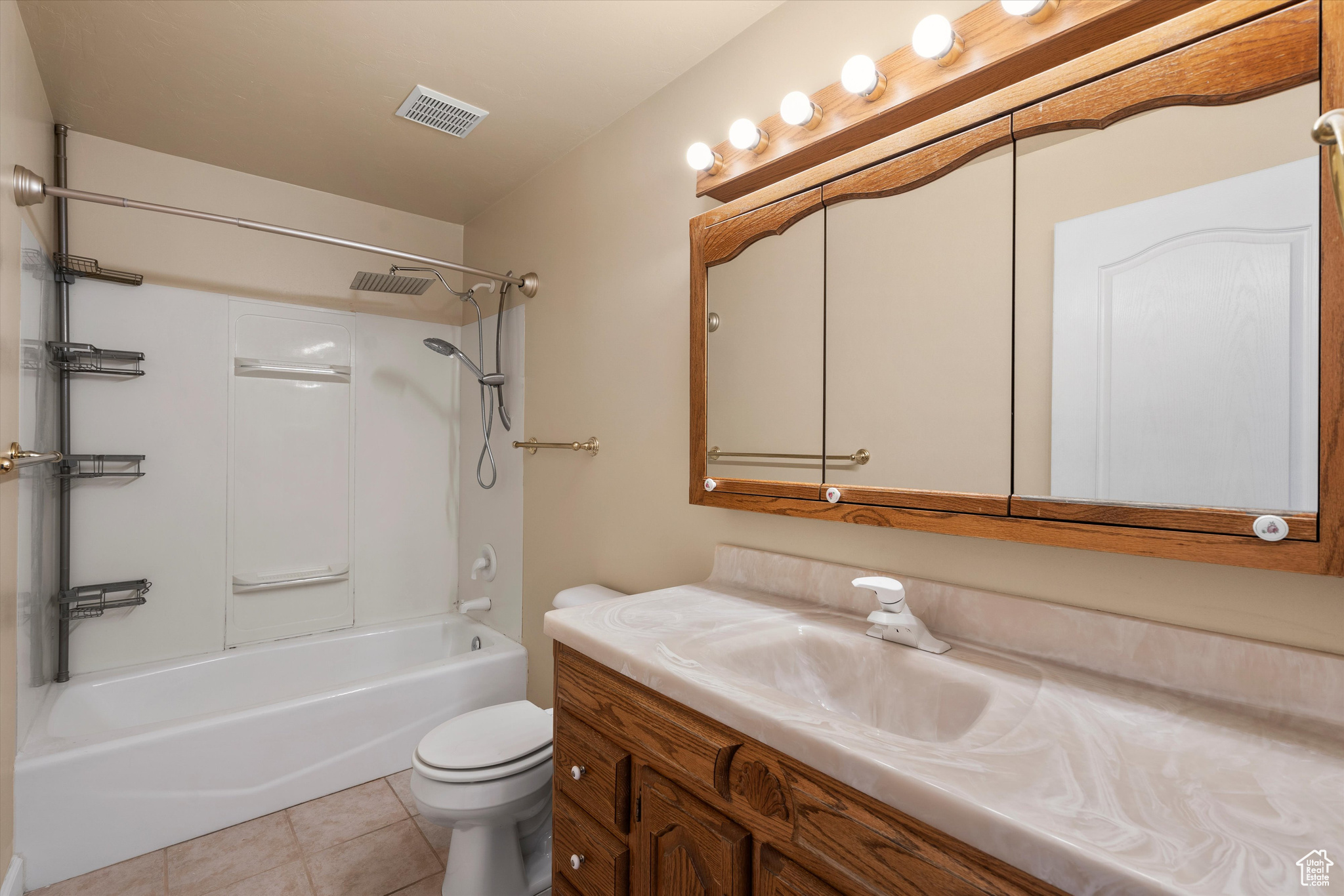 Full bathroom featuring shower / bath combination, vanity, toilet, and tile patterned floors