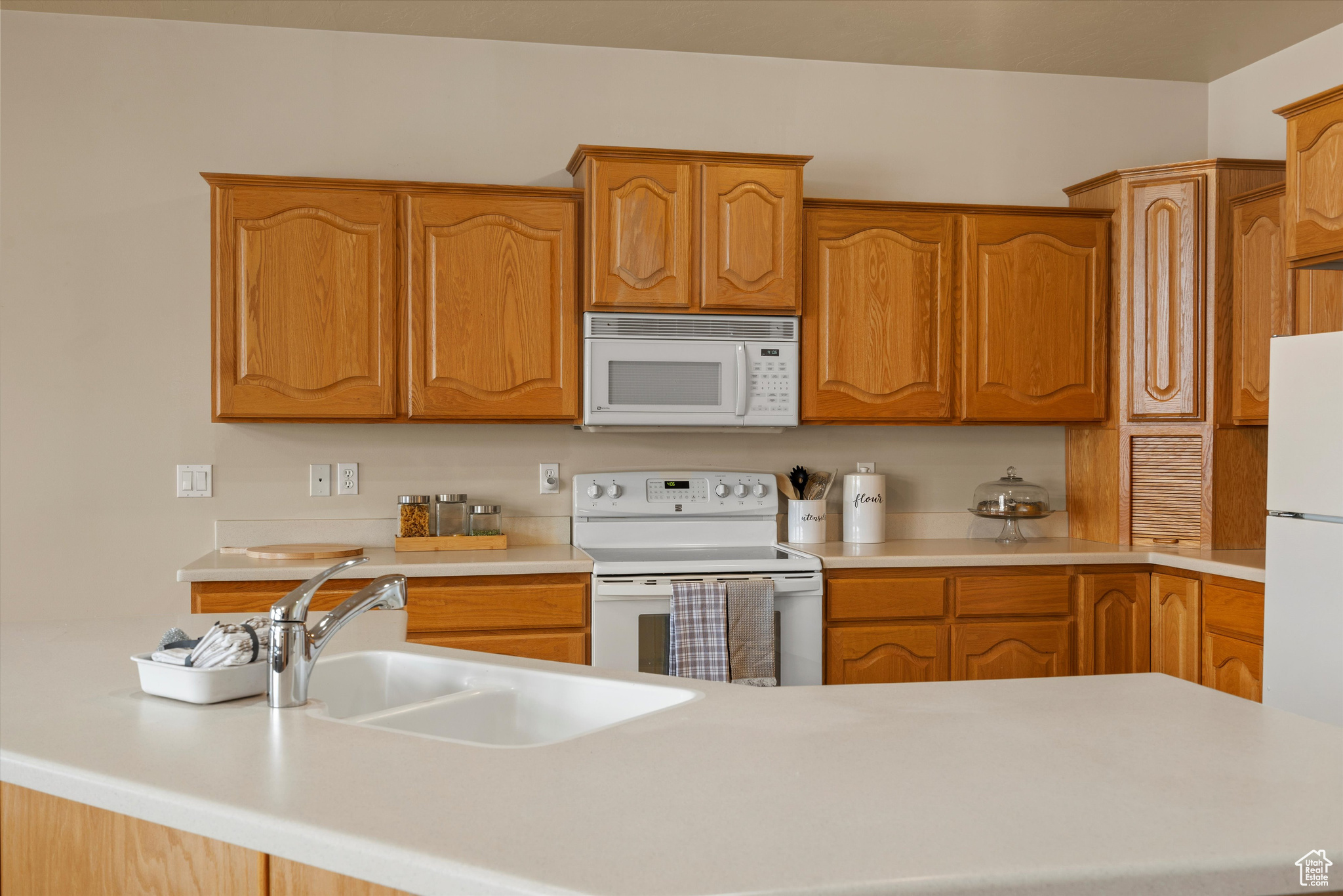 Kitchen featuring white appliances and sink