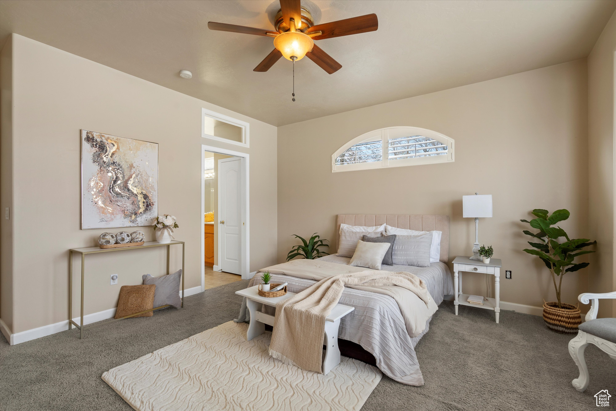 Carpeted bedroom with ceiling fan and ensuite bath
