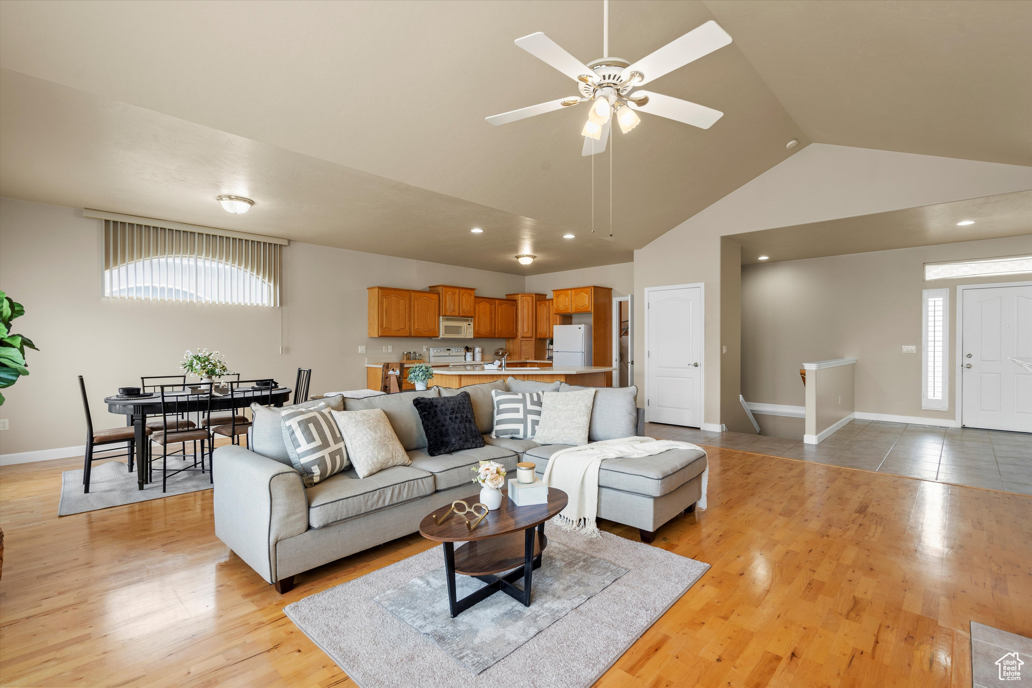 Living room featuring light hardwood / wood-style floors, high vaulted ceiling, and ceiling fan