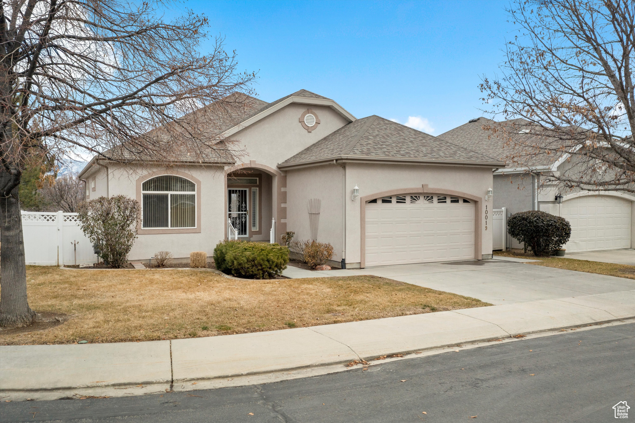 Single story home featuring a garage and a front yard