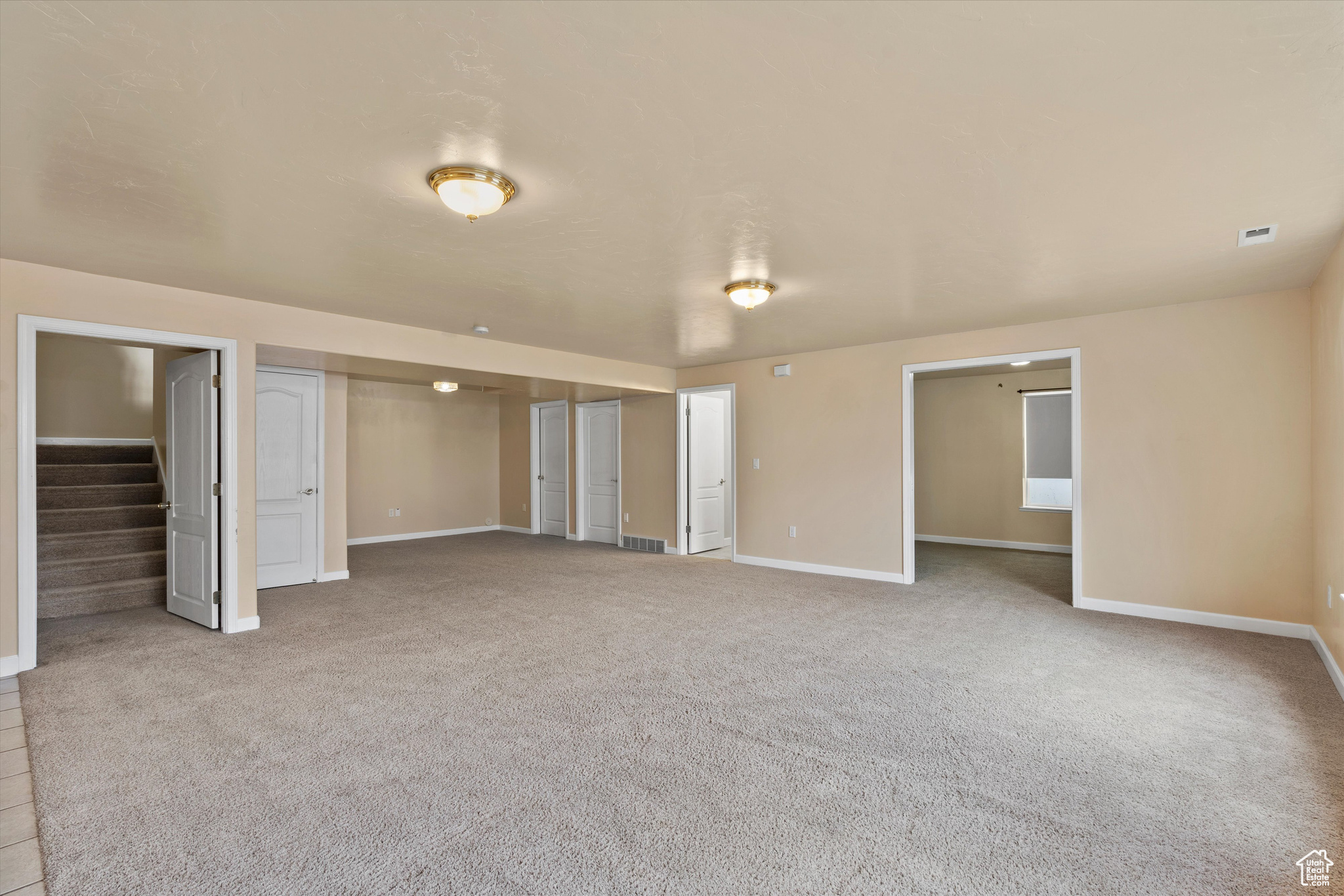 Unfurnished living room featuring light carpet
